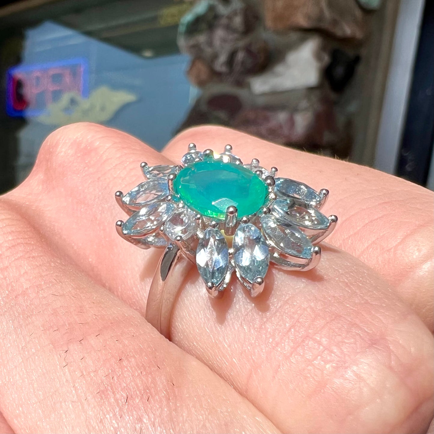 A faceted oval cut blue Ethiopian fire opal set in a sterling silver ring with marquise cut blue topaz stones.