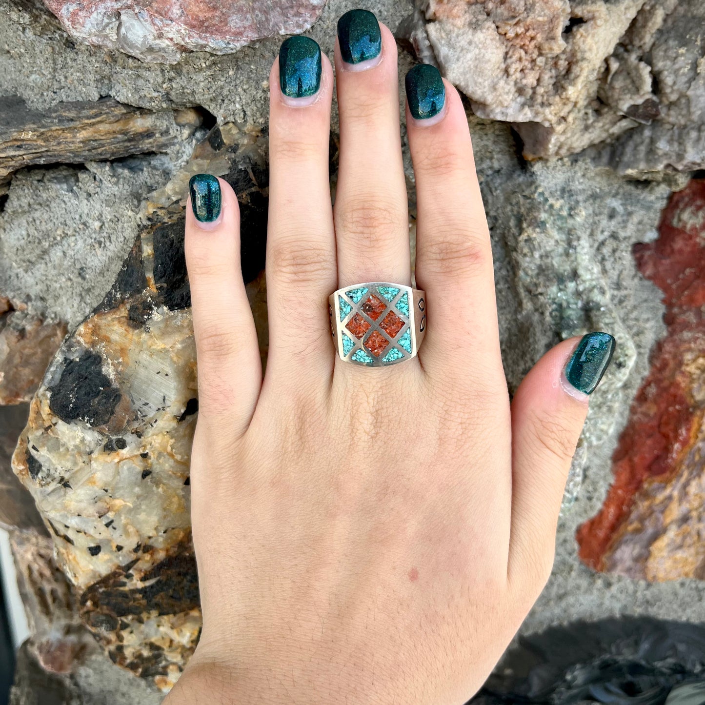 A men's sterling silver inlay ring set with sections of crushed blue turquoise and crushed red coral.