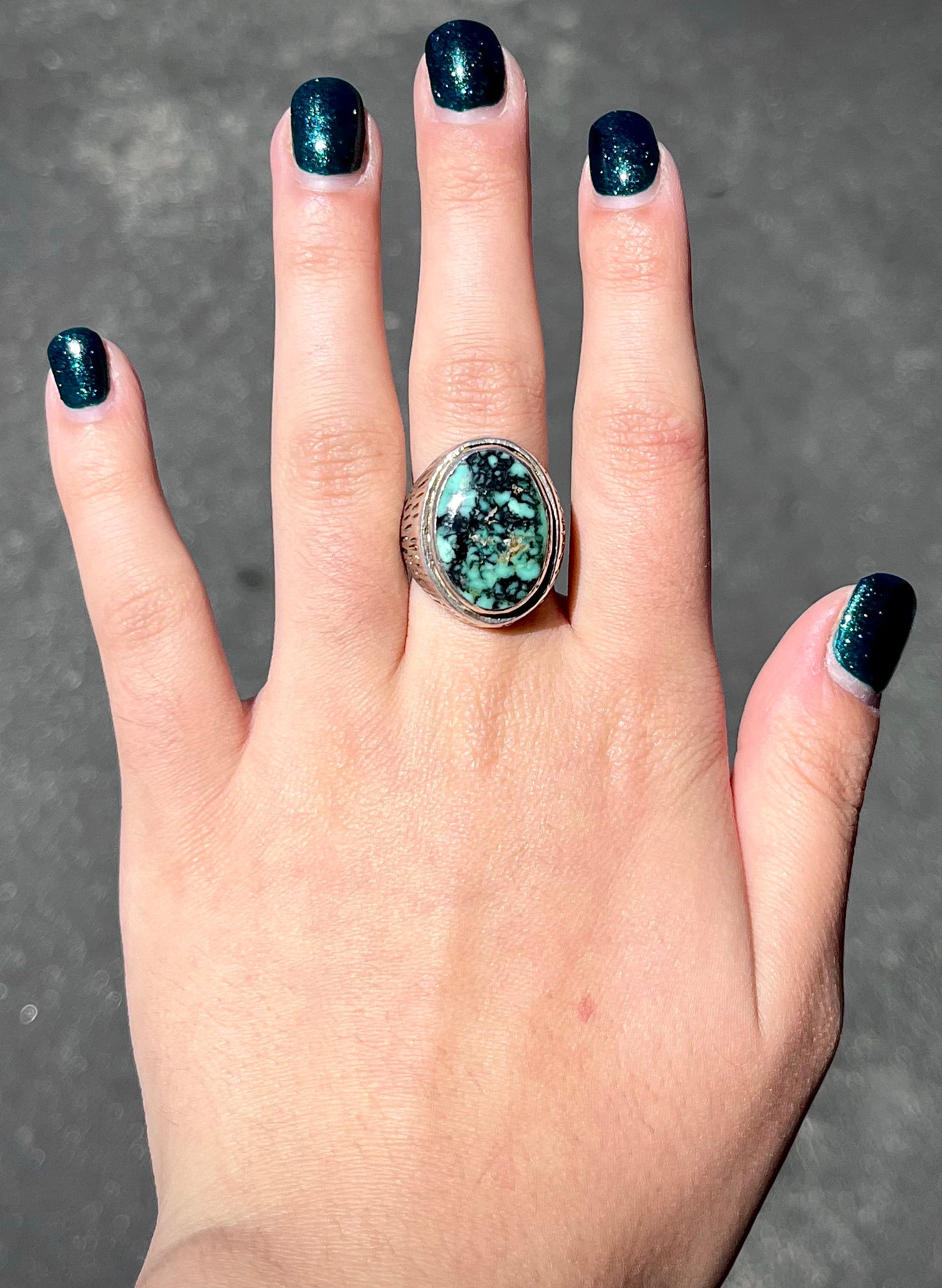 A sterling silver solitaire ring set with a black spiderweb turquoise stone from Kingman, Arizona.