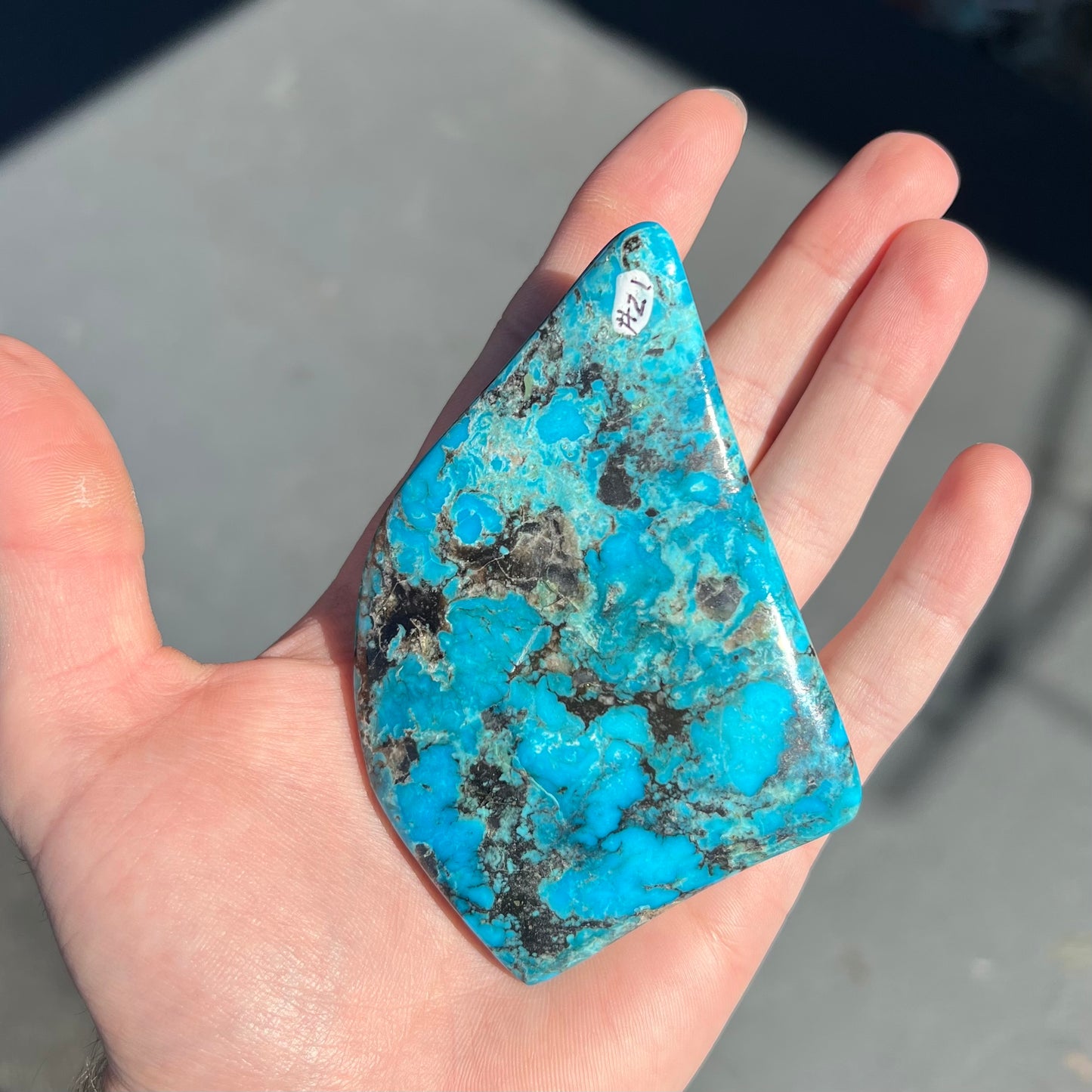 A large polished piece of Kingman turquoise. The stone is blue with black veining.
