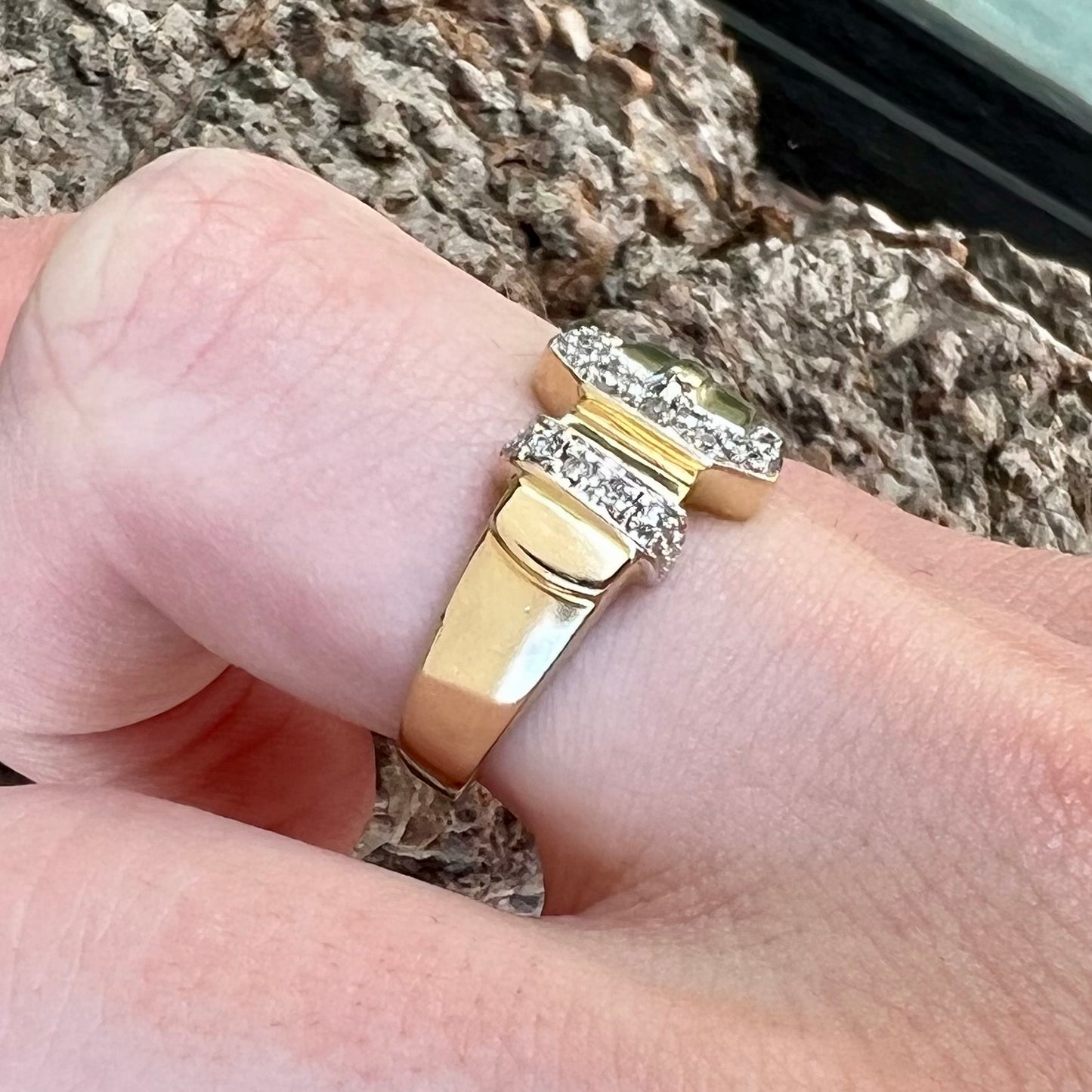 A yellow gold buckle ring set with round diamonds in the buckle.