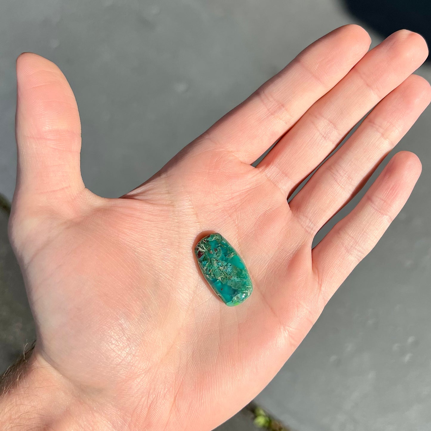 A loose, green, barrel cabochon shaped chrysocolla stone from Morenci, Arizona.