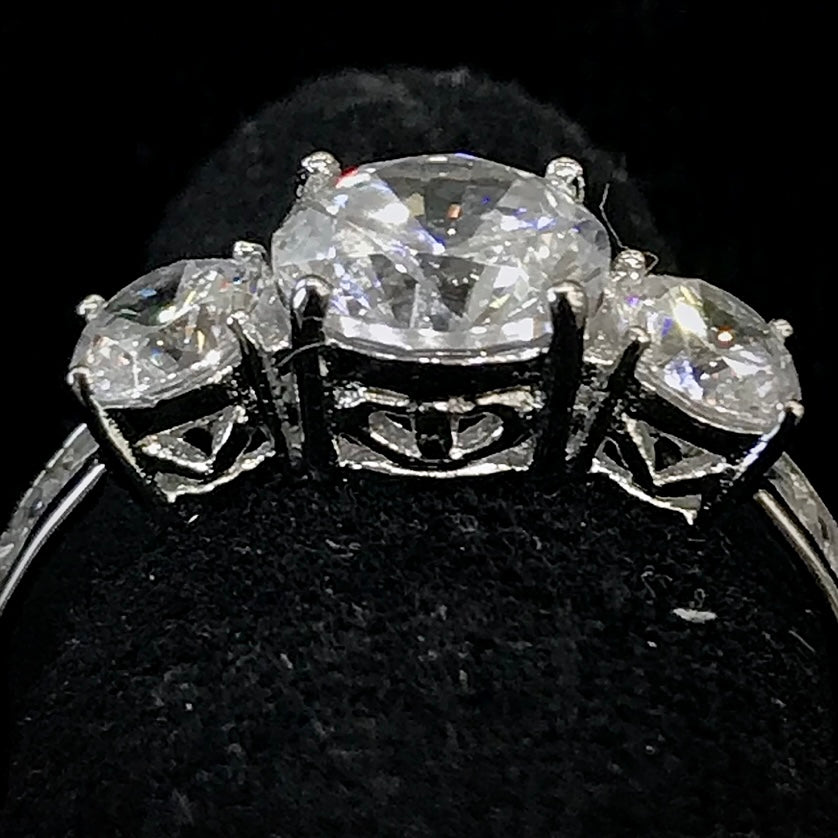 A sterling silver ring set with three round cut cubic zirconia stones.