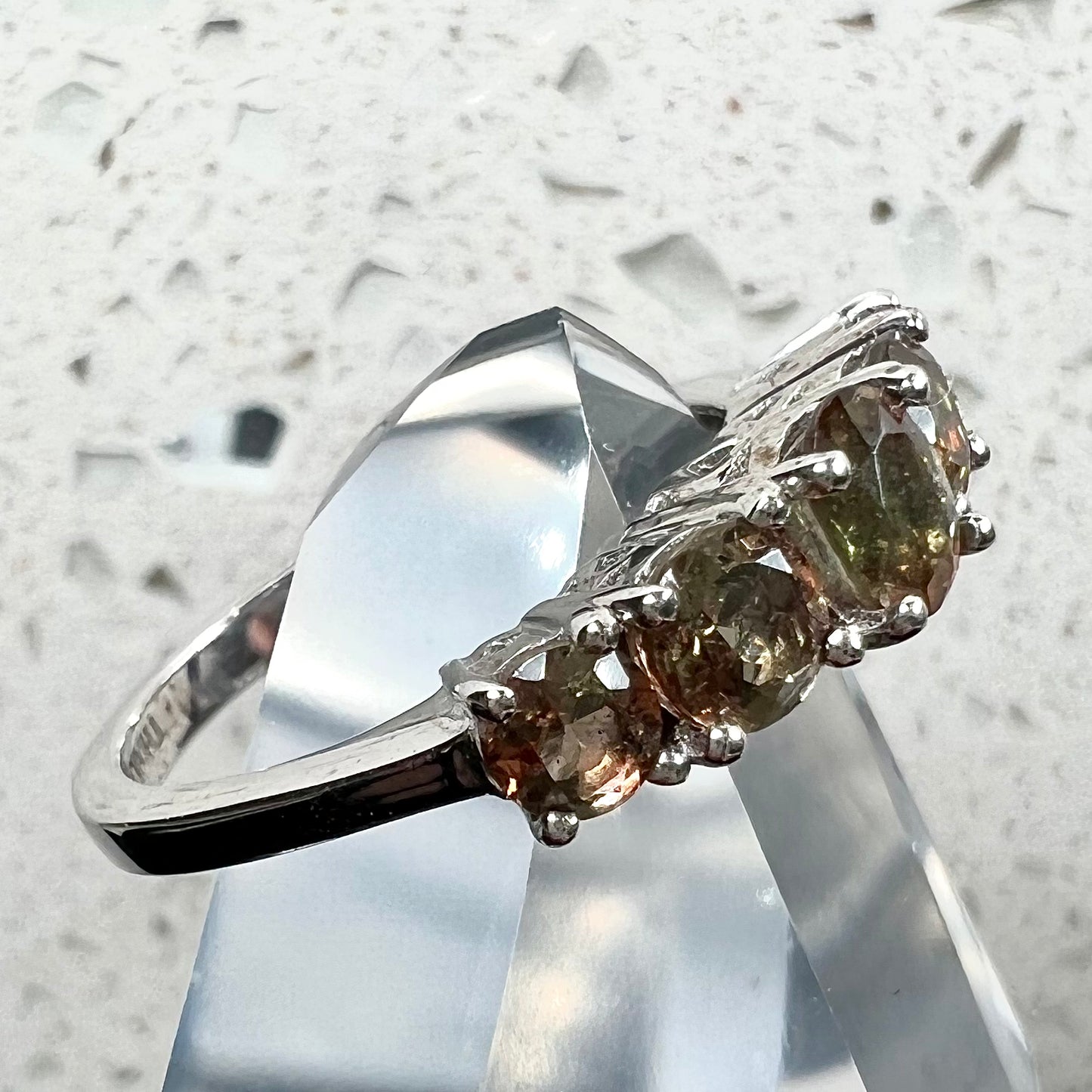 A sterling silver stackable ring set with five faceted oval and round andalusite stones.