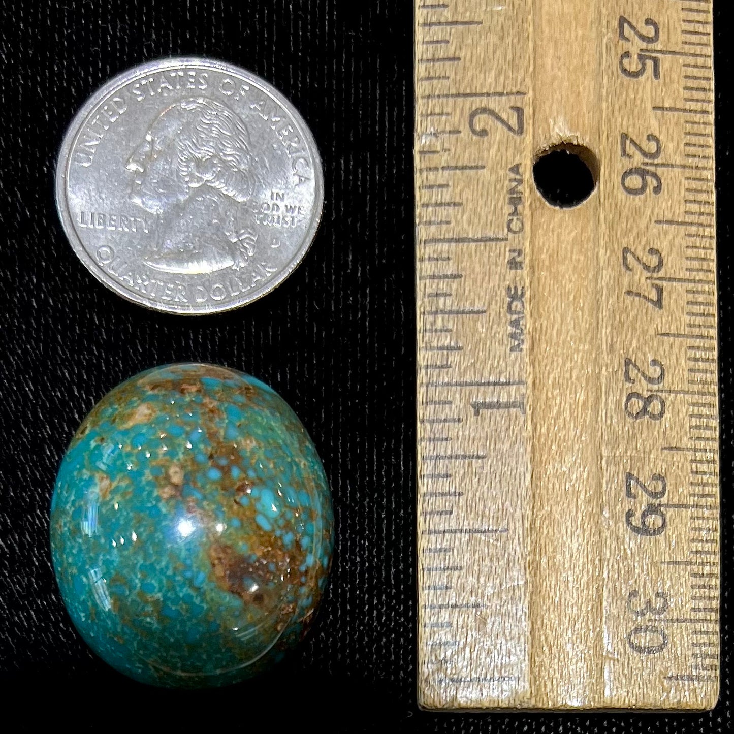 An oval cabochon cut green Royston turquoise with brown matrix.