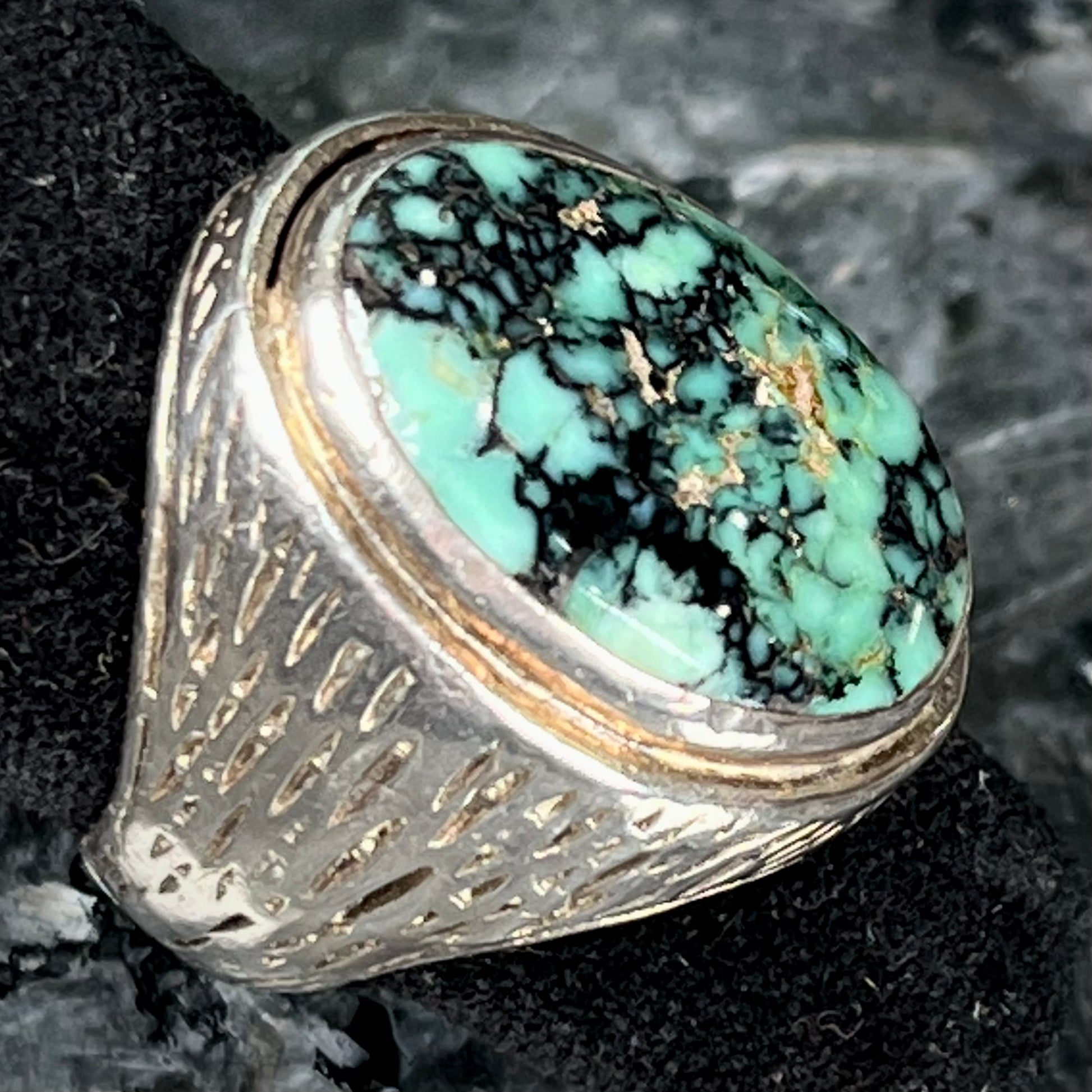 A sterling silver solitaire ring set with a black spiderweb turquoise stone from Kingman, Arizona.
