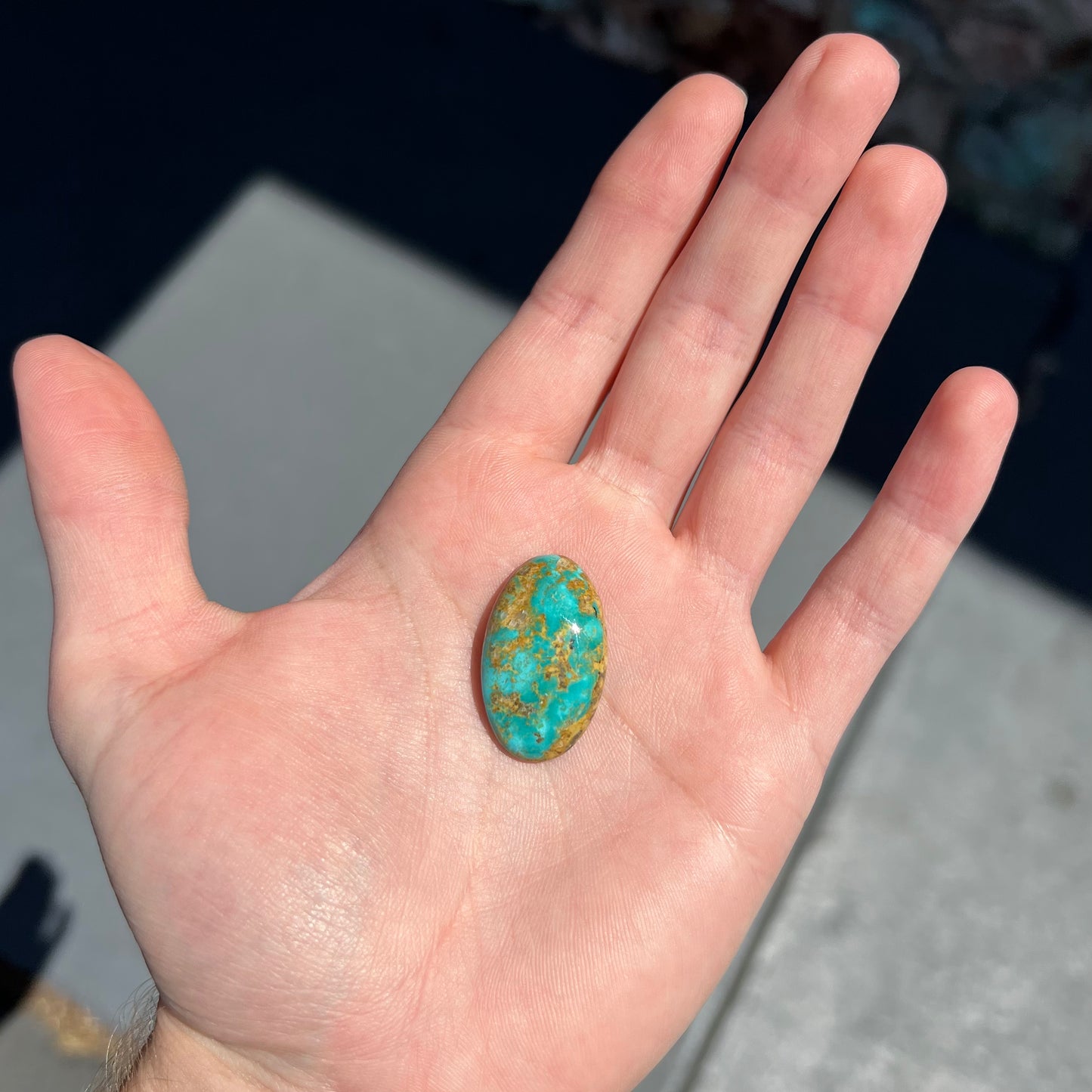 An oval cabochon cut turquoise stone from Manassa, Colorado.