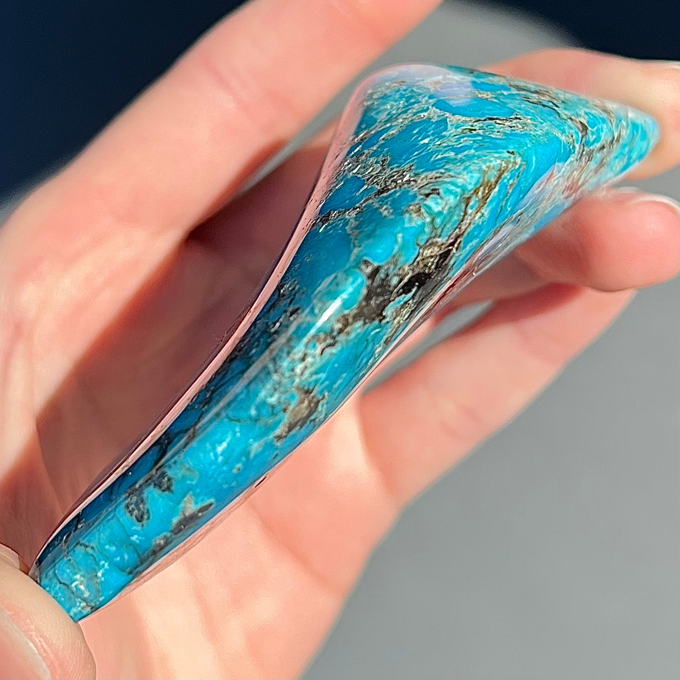 A large polished piece of Kingman turquoise. The stone is blue with black veining.