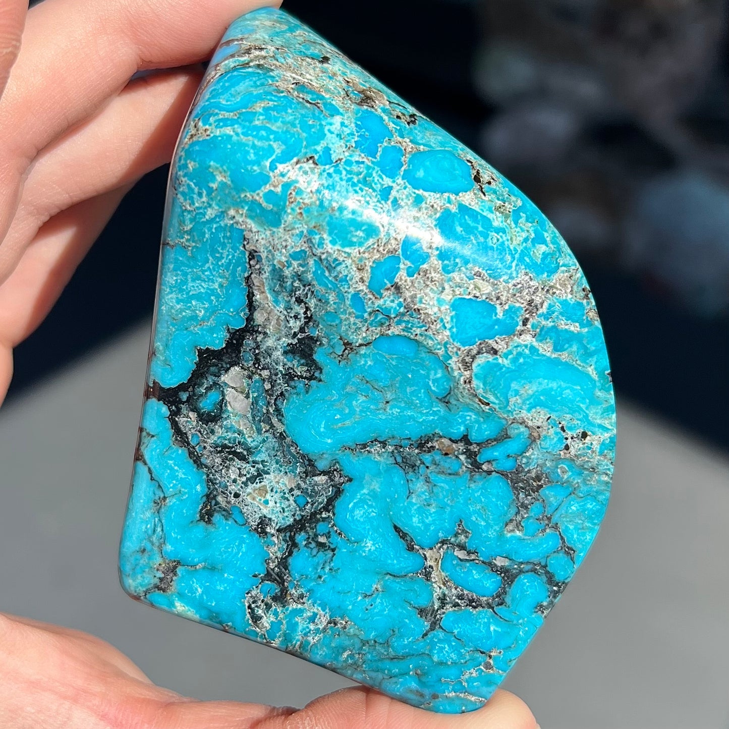 A large polished piece of Kingman turquoise. The stone is blue with black veining.