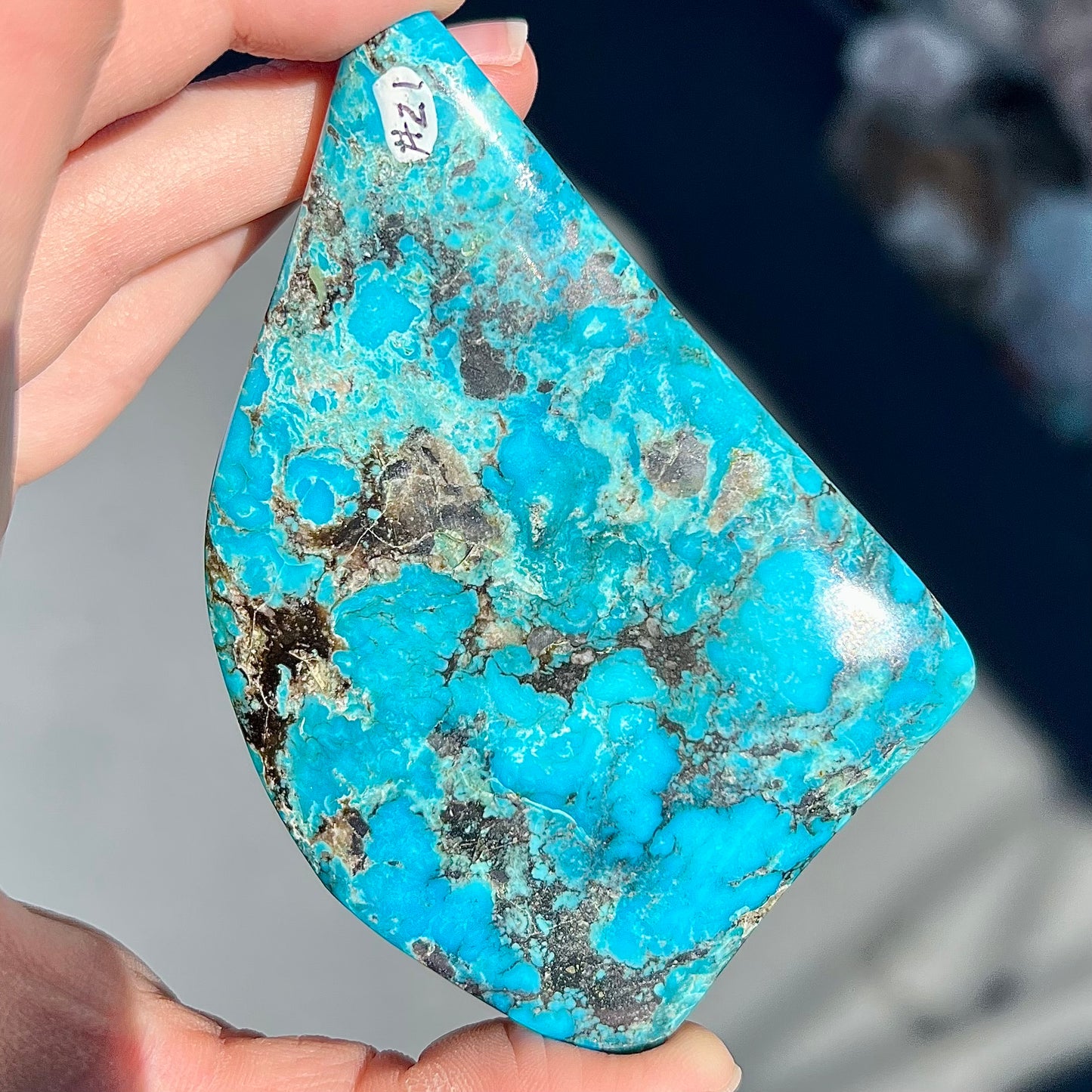 A large polished piece of Kingman turquoise. The stone is blue with black veining.