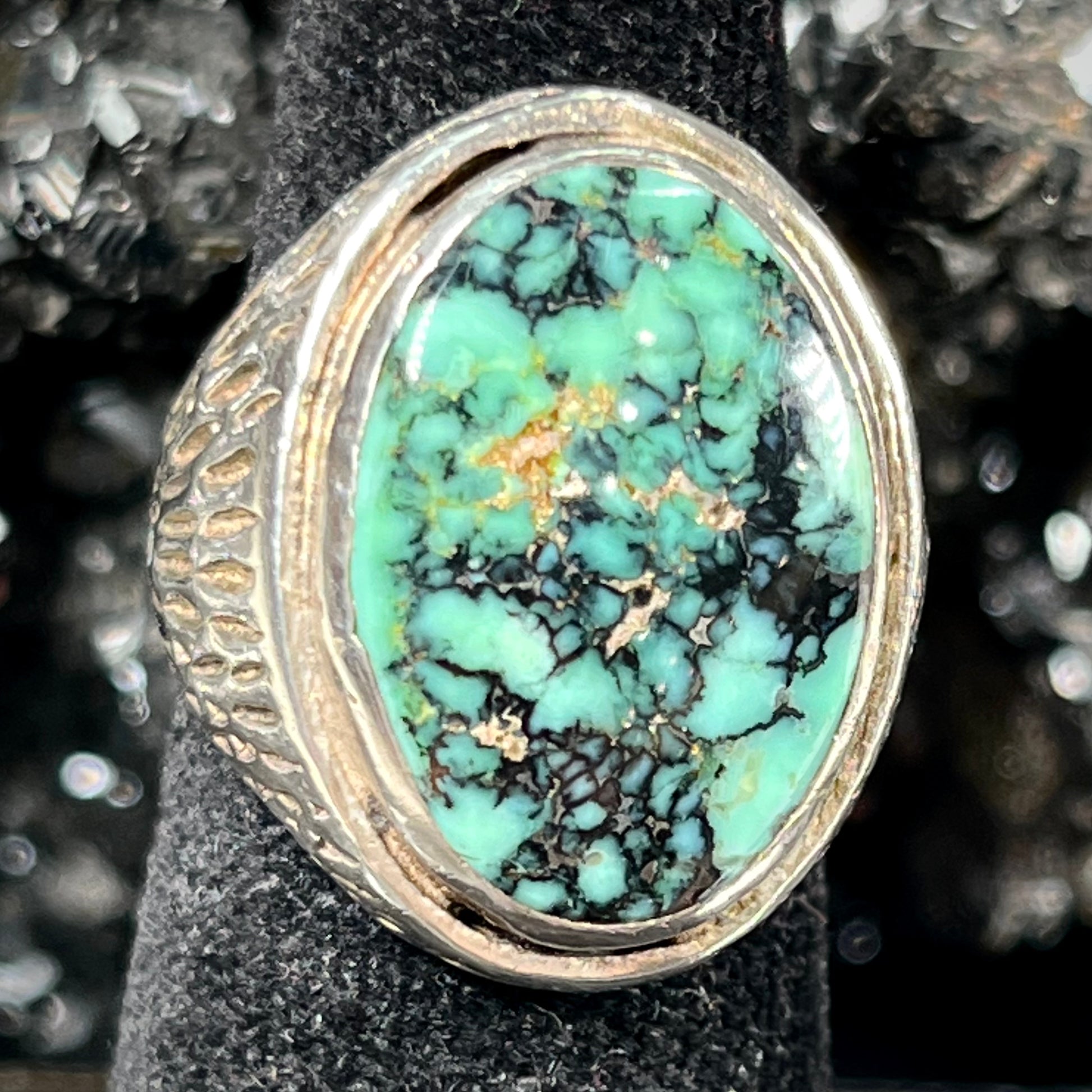 A sterling silver solitaire ring set with a black spiderweb turquoise stone from Kingman, Arizona.