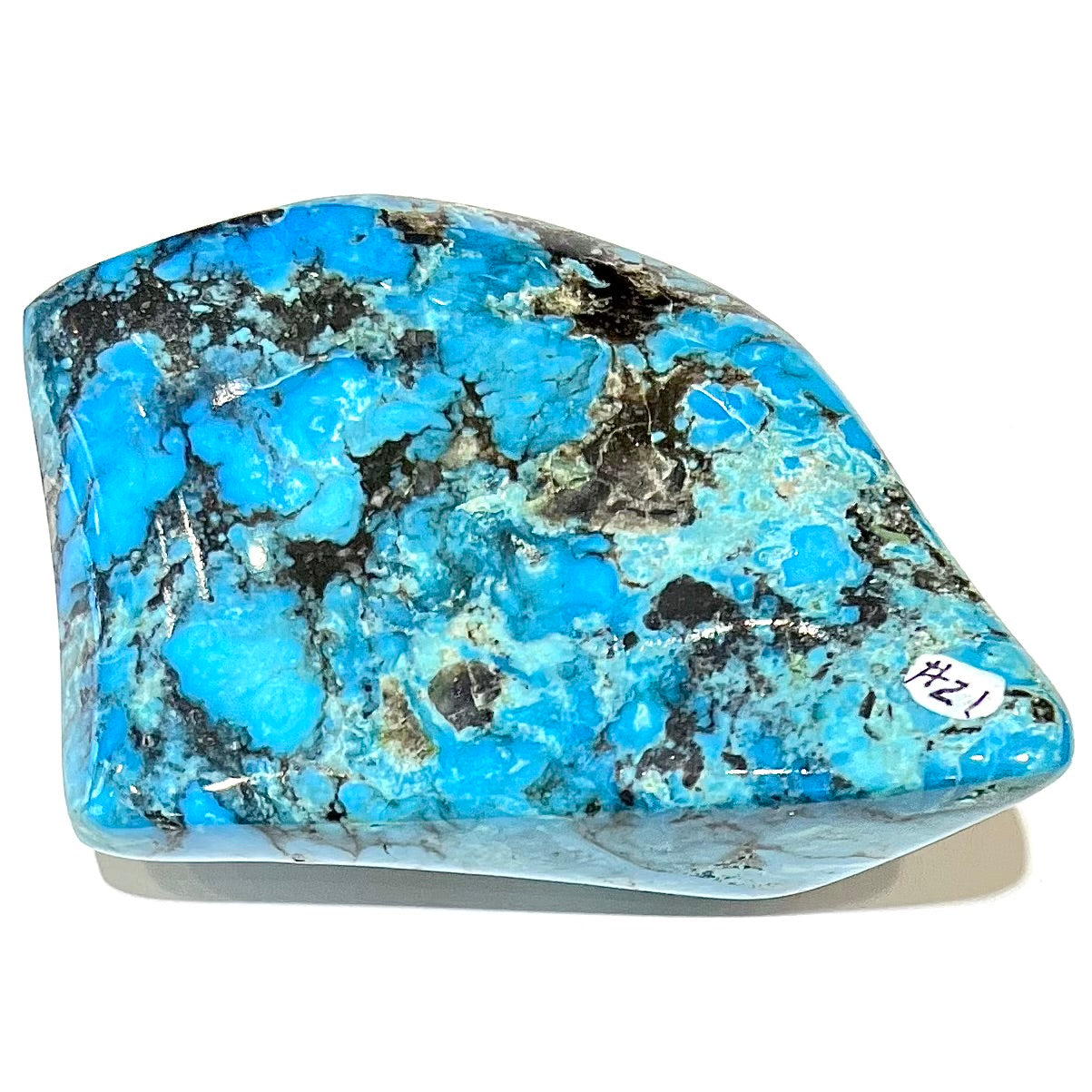 A large polished piece of Kingman turquoise. The stone is blue with black veining.