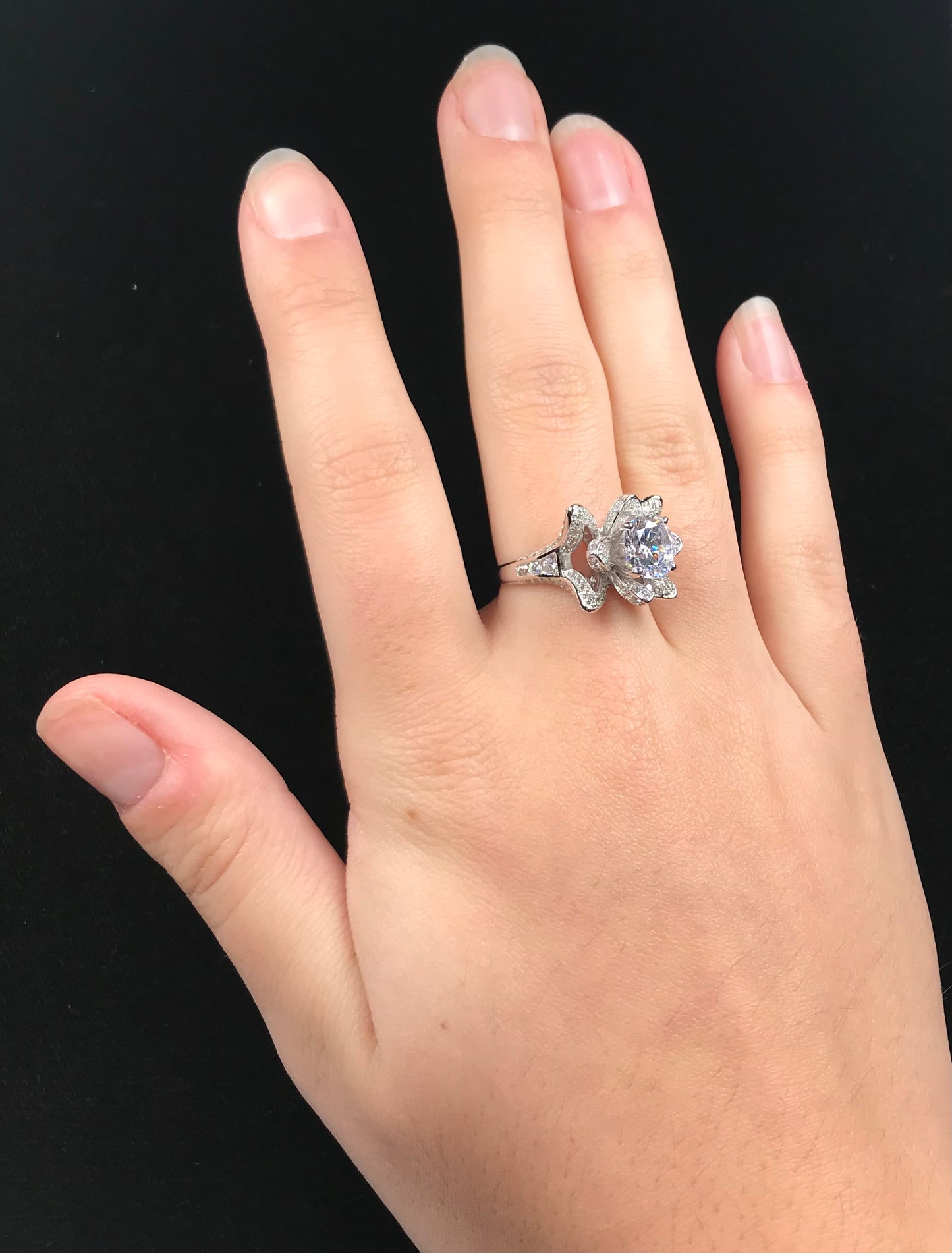 A blooming flower motif ring set with round, white cubic zirconia.