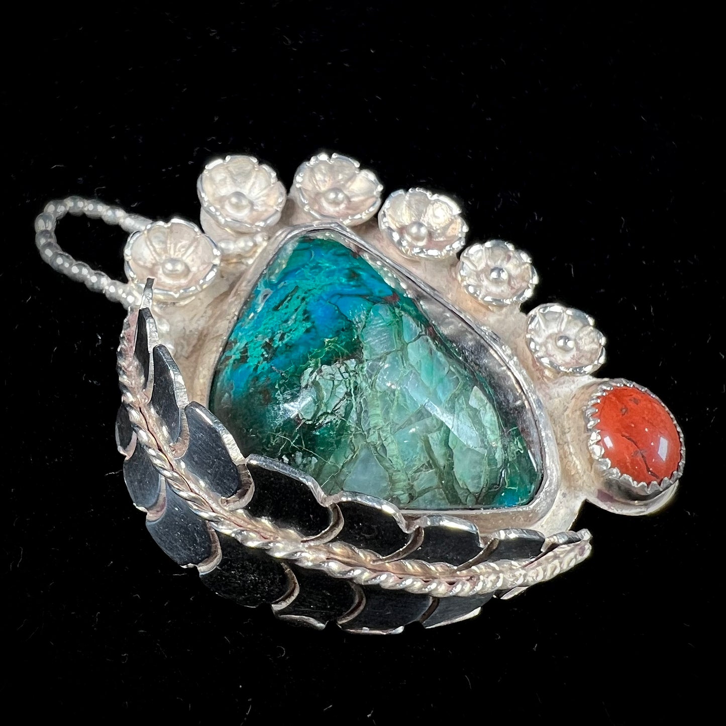 A sterling silver Navajo-style pendant set with chrysocolla and red jasper stones.