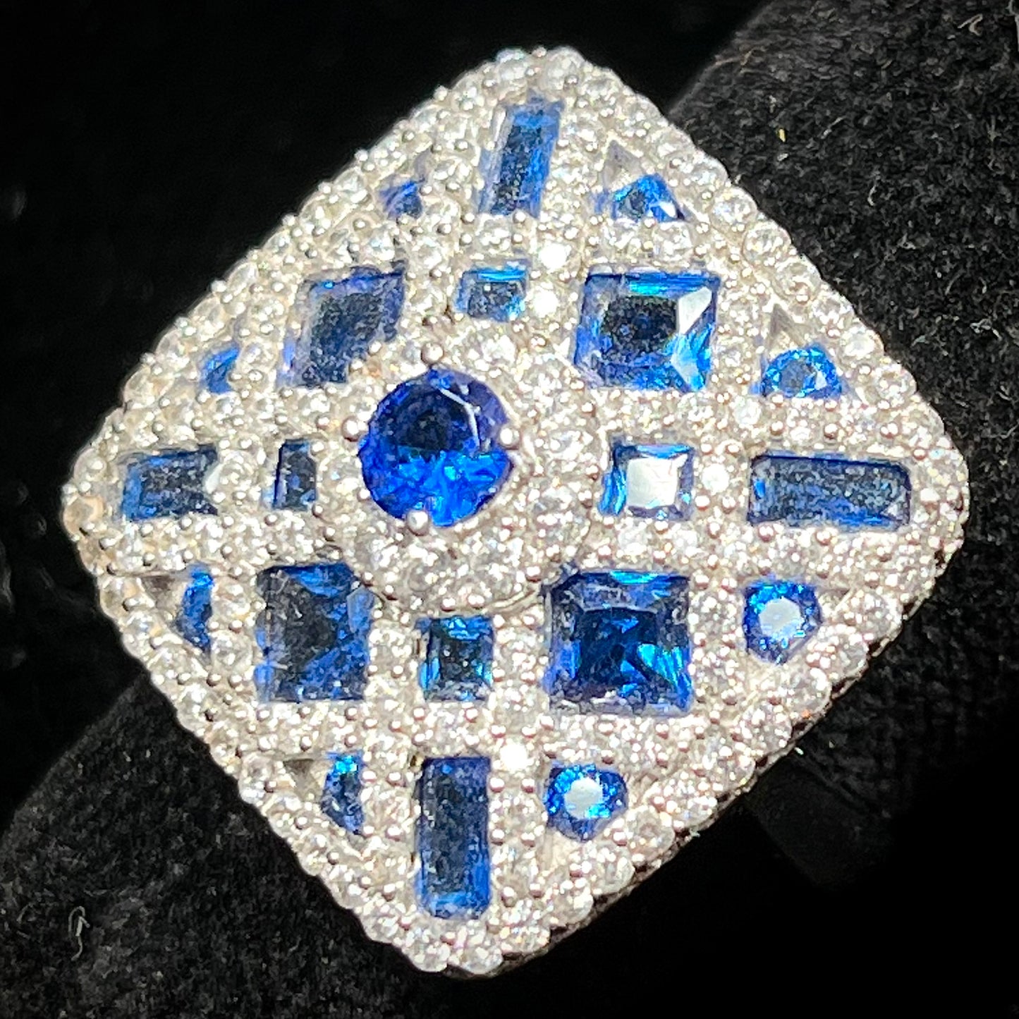 A sterling silver blue and white synthetic stone ring. The ring strongly resembles a blueberry pie.