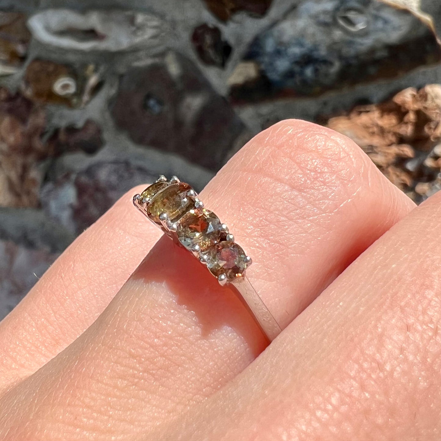 A sterling silver stackable ring set with five faceted oval and round andalusite stones.