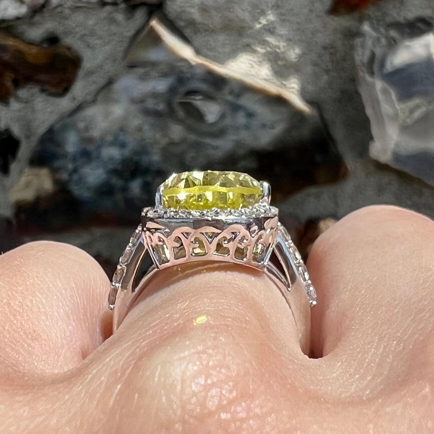 A pear shape lemon quartz set in a sterling silver and white topaz halo ring.