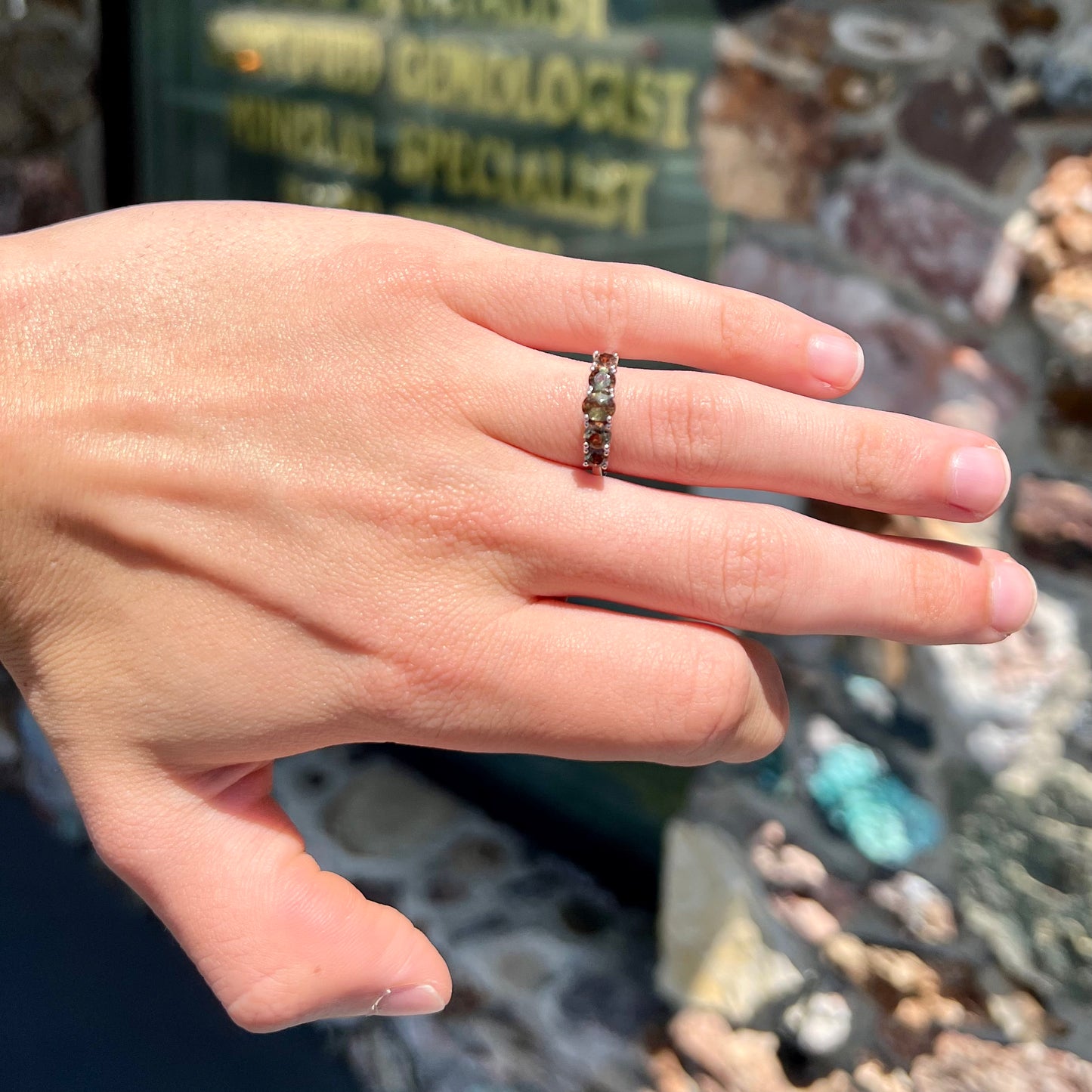 A sterling silver stackable ring set with five faceted oval and round andalusite stones.