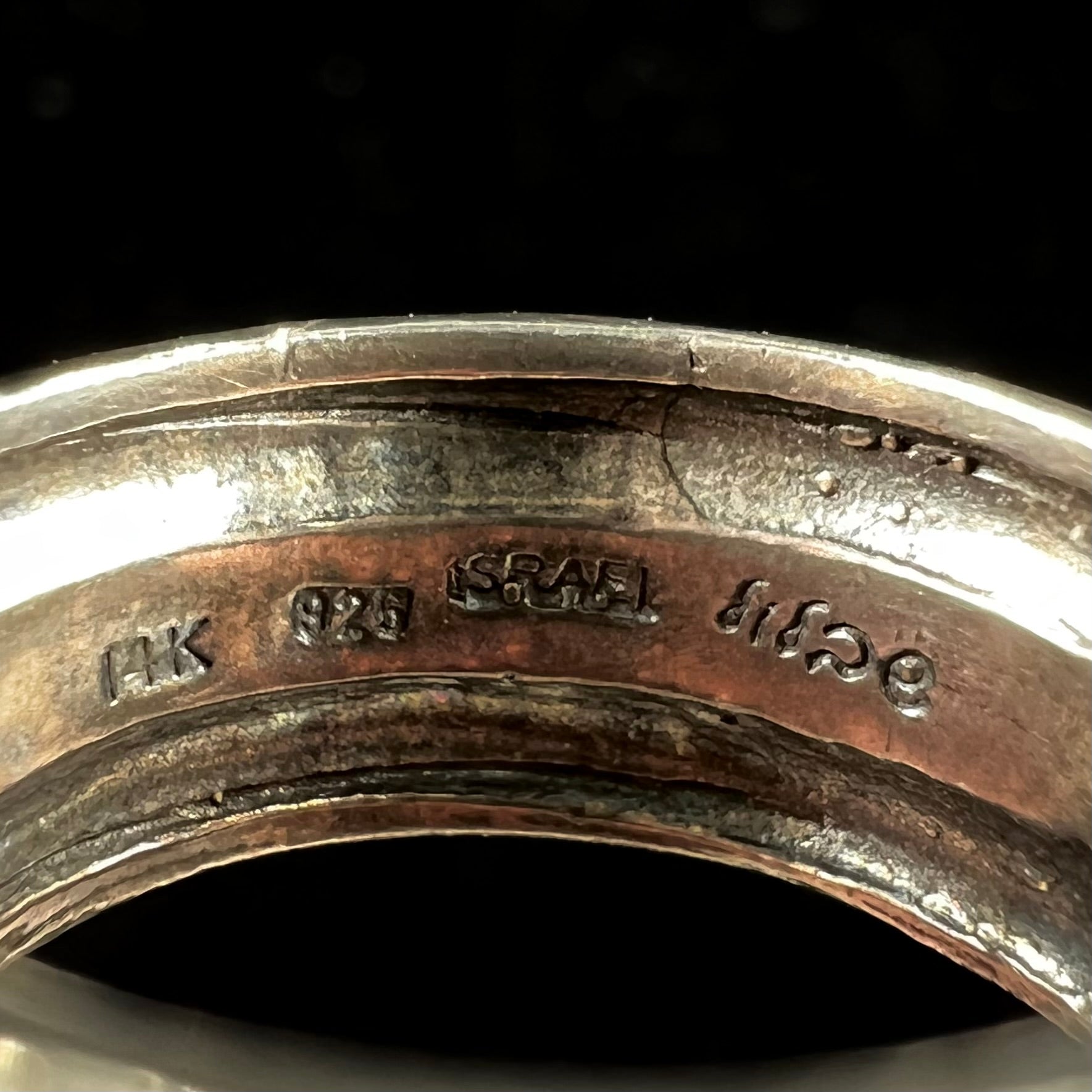 A filigree etched two tone silver and gold spinner ring set with a lab created black opal.