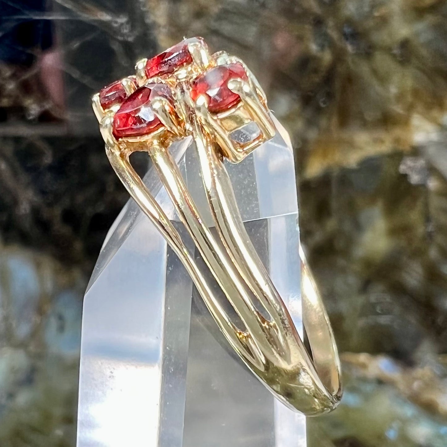 A yellow gold multishank ring set with two heart shape and two round cut red garnets.