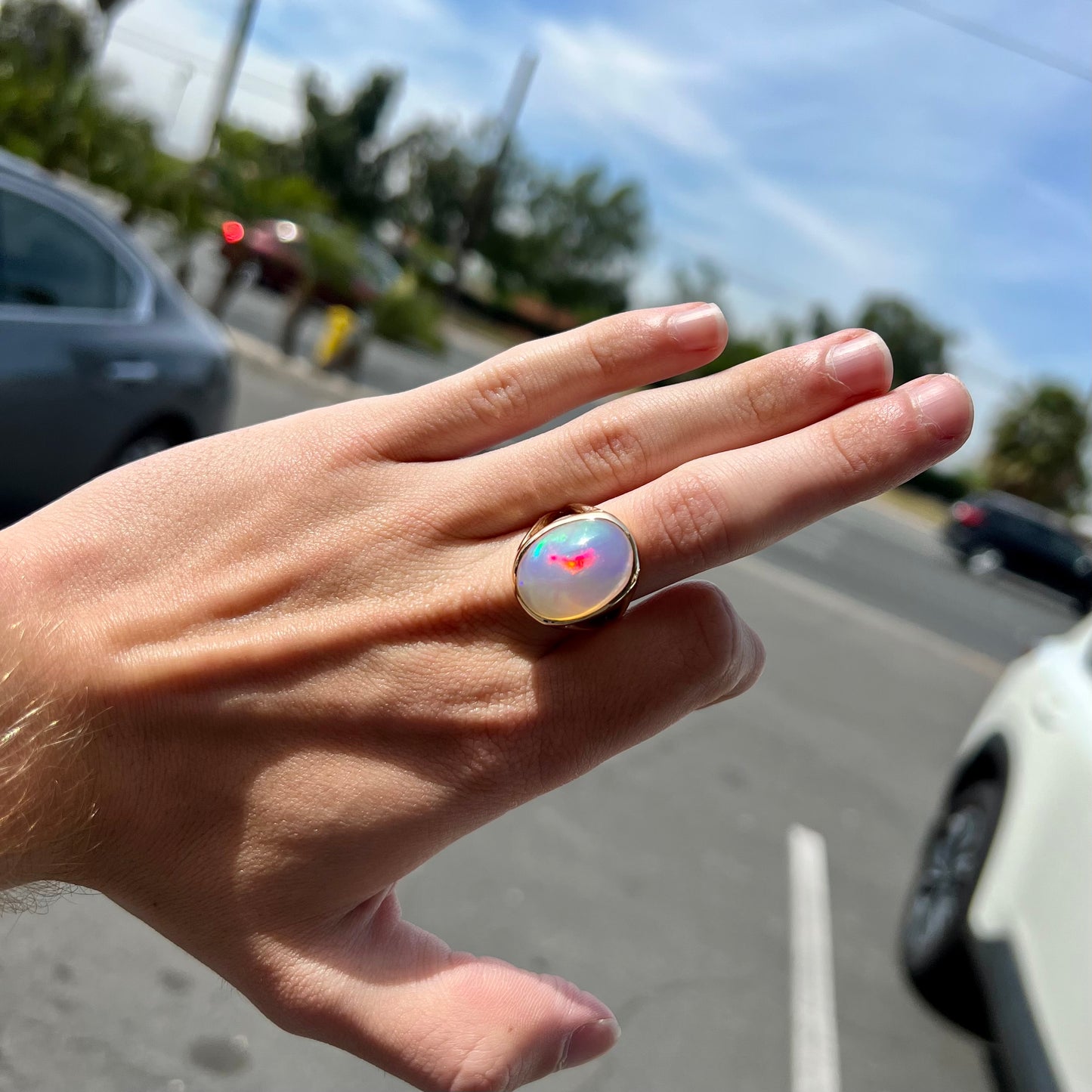 A gold split shank solitaire ring set with an oval cabochon cut 16.83 carat Ethiopian jelly fire opal.