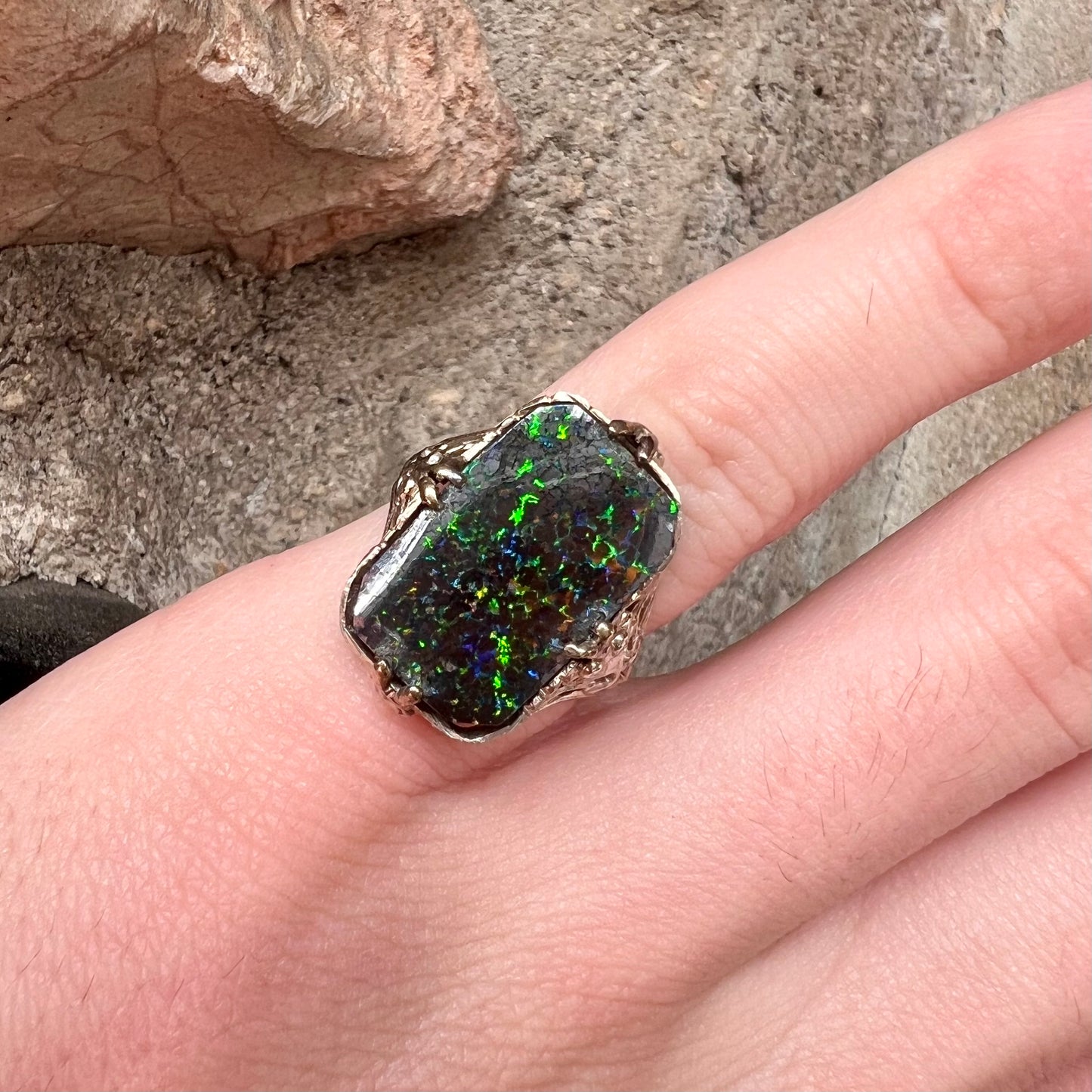 A vintage, white gold filigree unisex ring set with a black Koroit boulder opal.