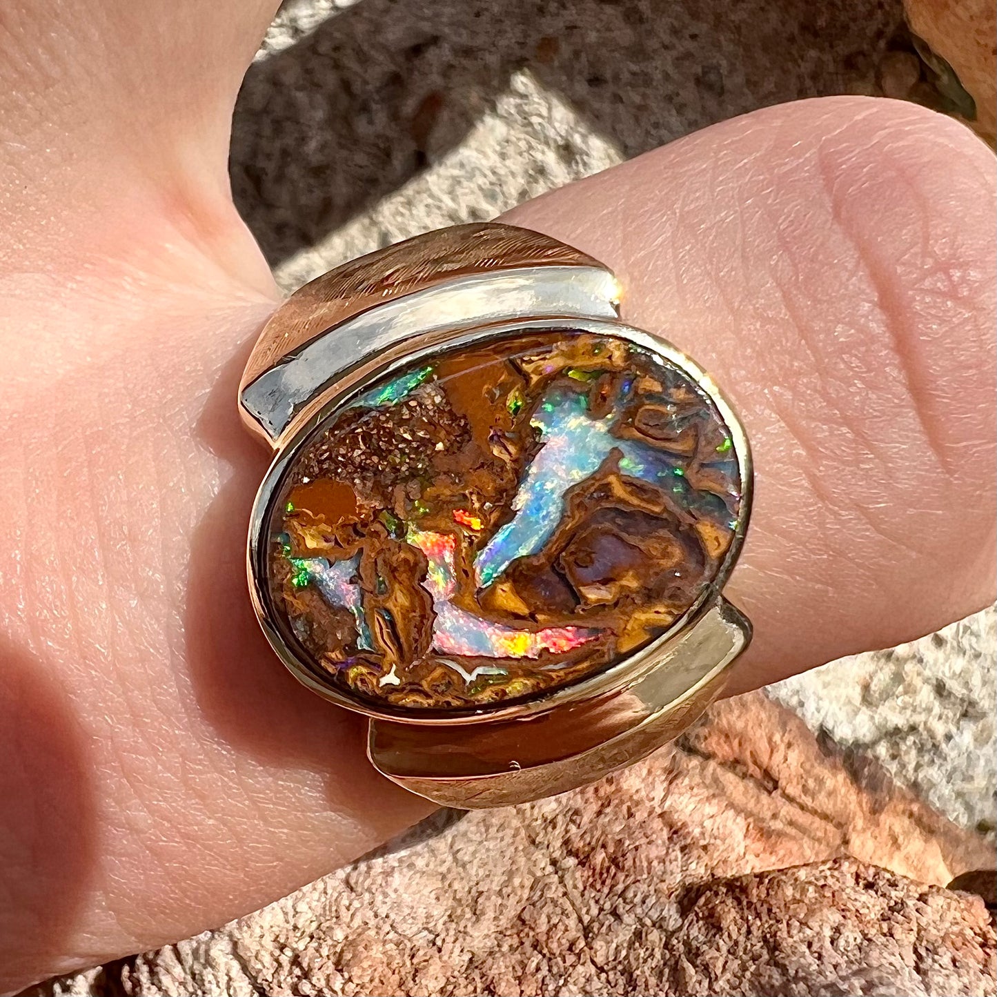 A Koroit boulder opal men's ring in brushed yellow gold.