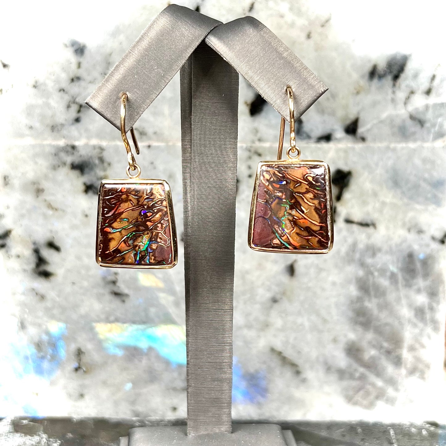 A pair of yellow gold French wire dangle earrings set with Koroit boulder opal.