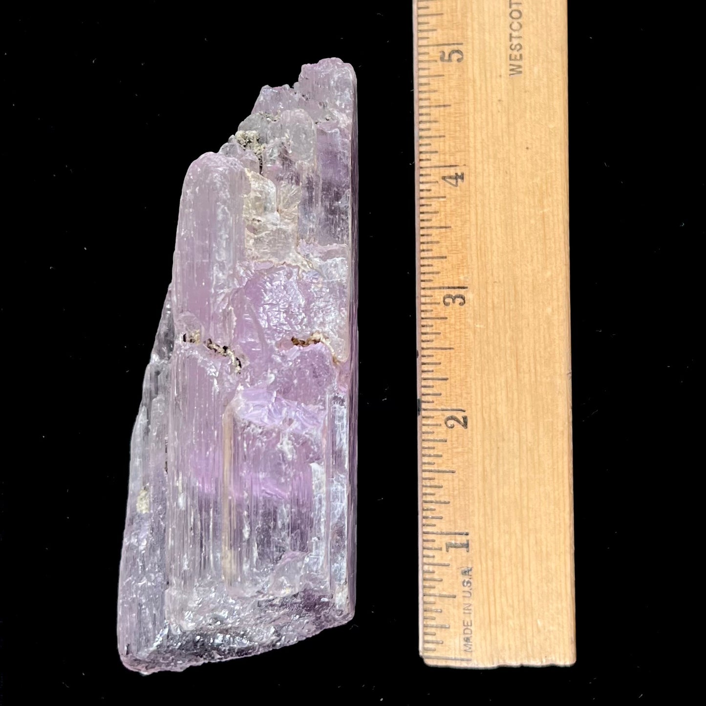 A five inch long pink kunzite crystal. The crystal is purple when viewed down the ends.