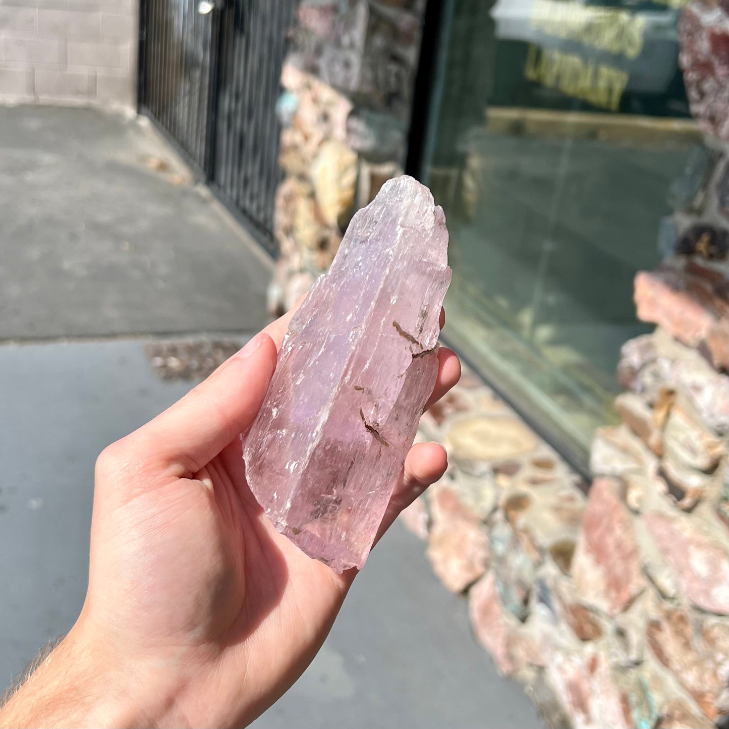 A five inch long pink kunzite crystal. The crystal is purple when viewed down the ends.