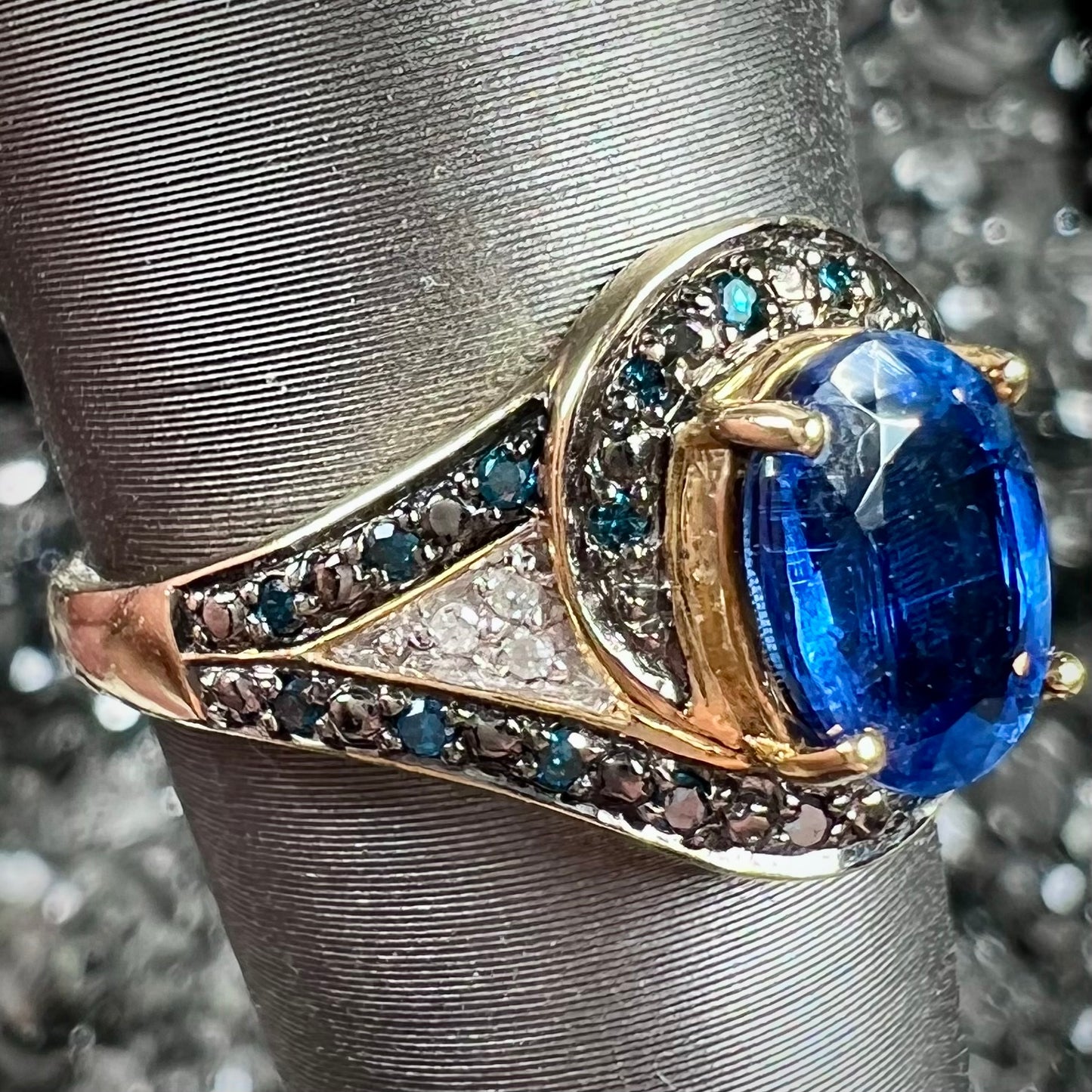 A ladies' oval cut blue kyanite twist ring pave set with blue and white diamond accents.