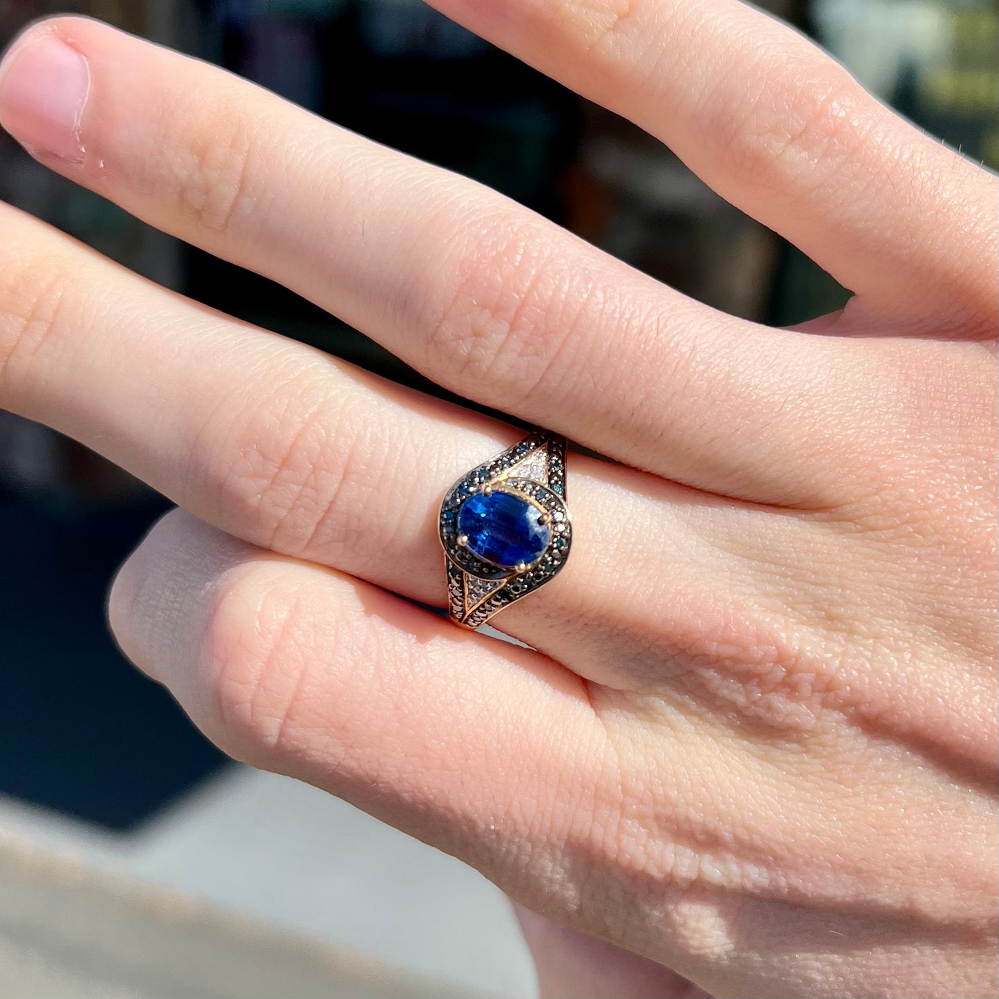 A ladies' oval cut blue kyanite twist ring pave set with blue and white diamond accents.