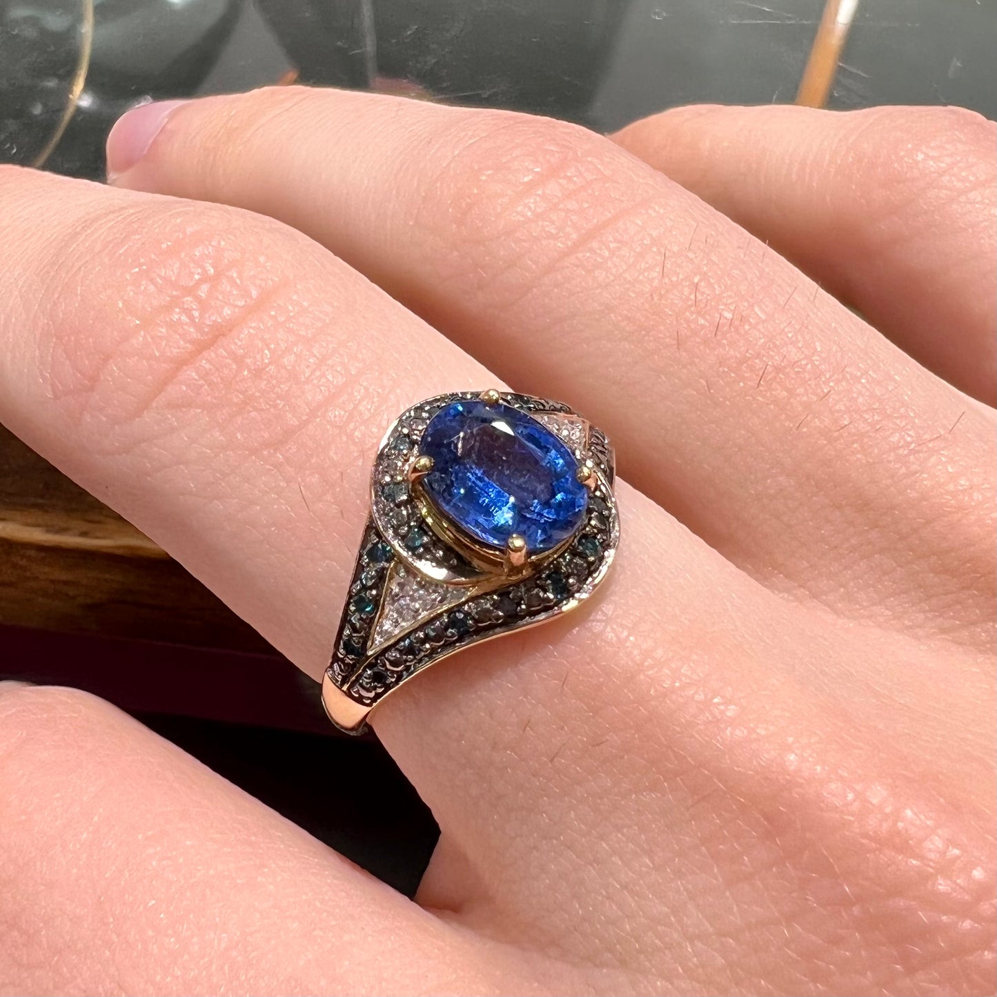 A ladies' oval cut blue kyanite twist ring pave set with blue and white diamond accents.
