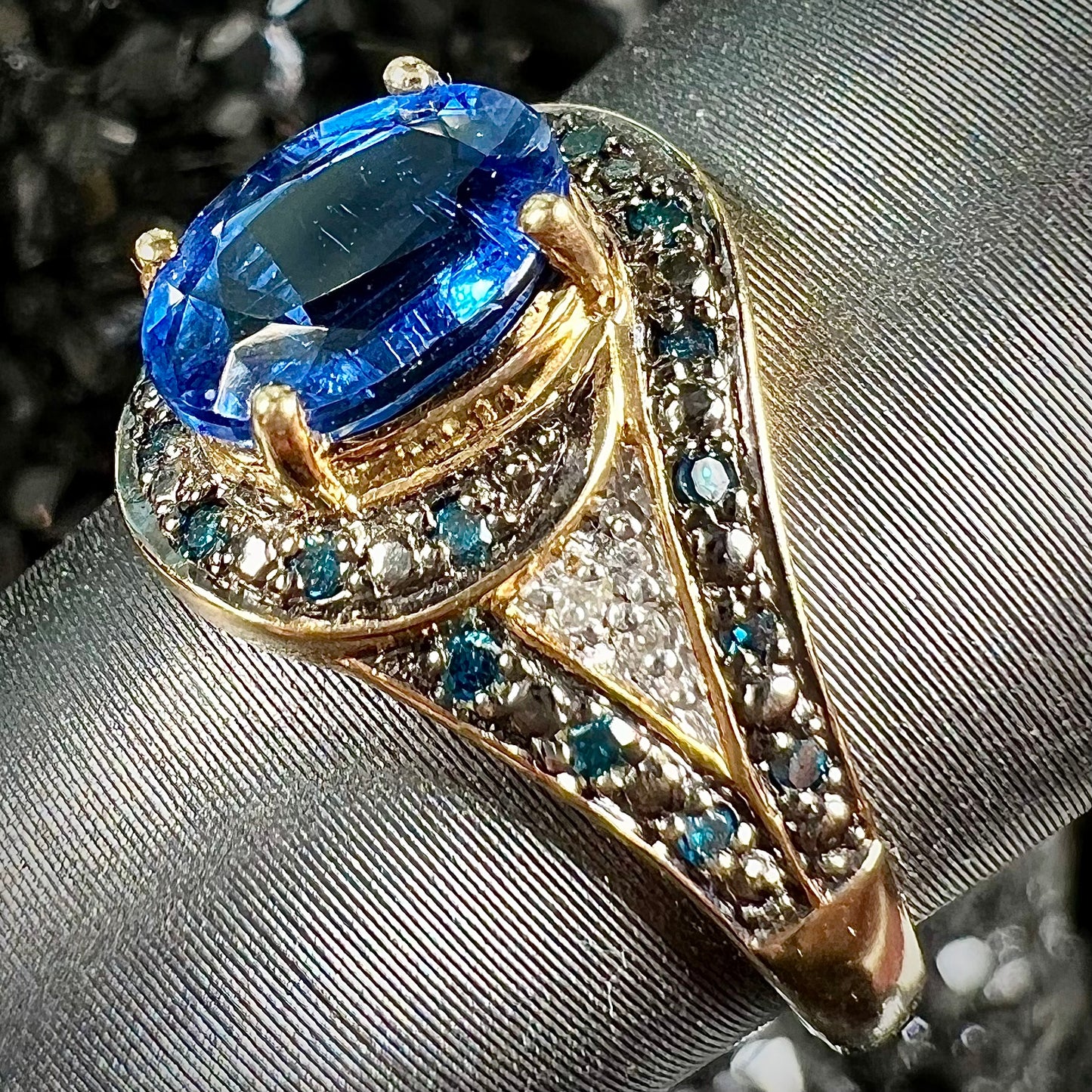 A ladies' oval cut blue kyanite twist ring pave set with blue and white diamond accents.