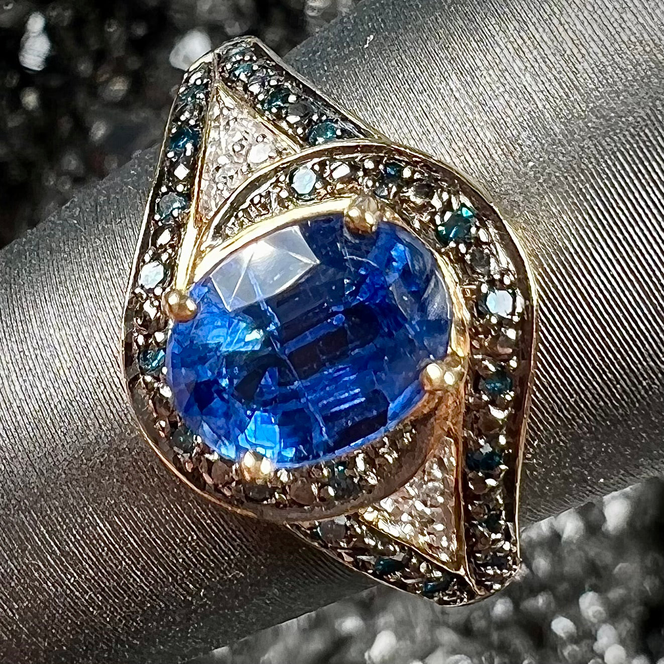 A ladies' oval cut blue kyanite twist ring pave set with blue and white diamond accents.