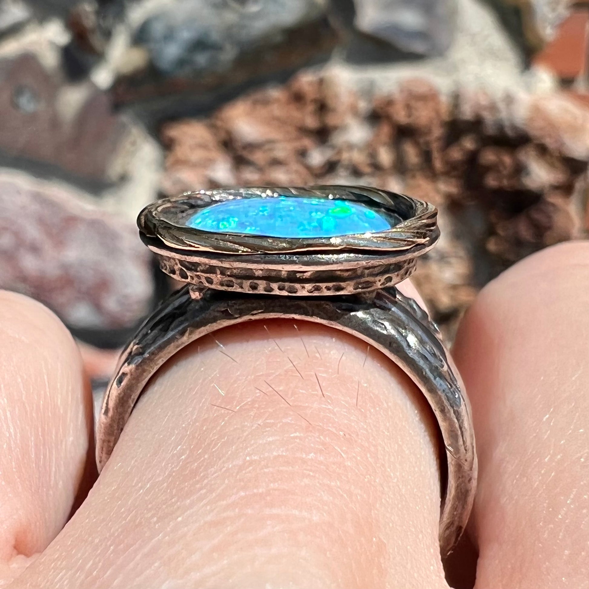 A filigree etched two tone silver and gold spinner ring set with a lab created black opal.