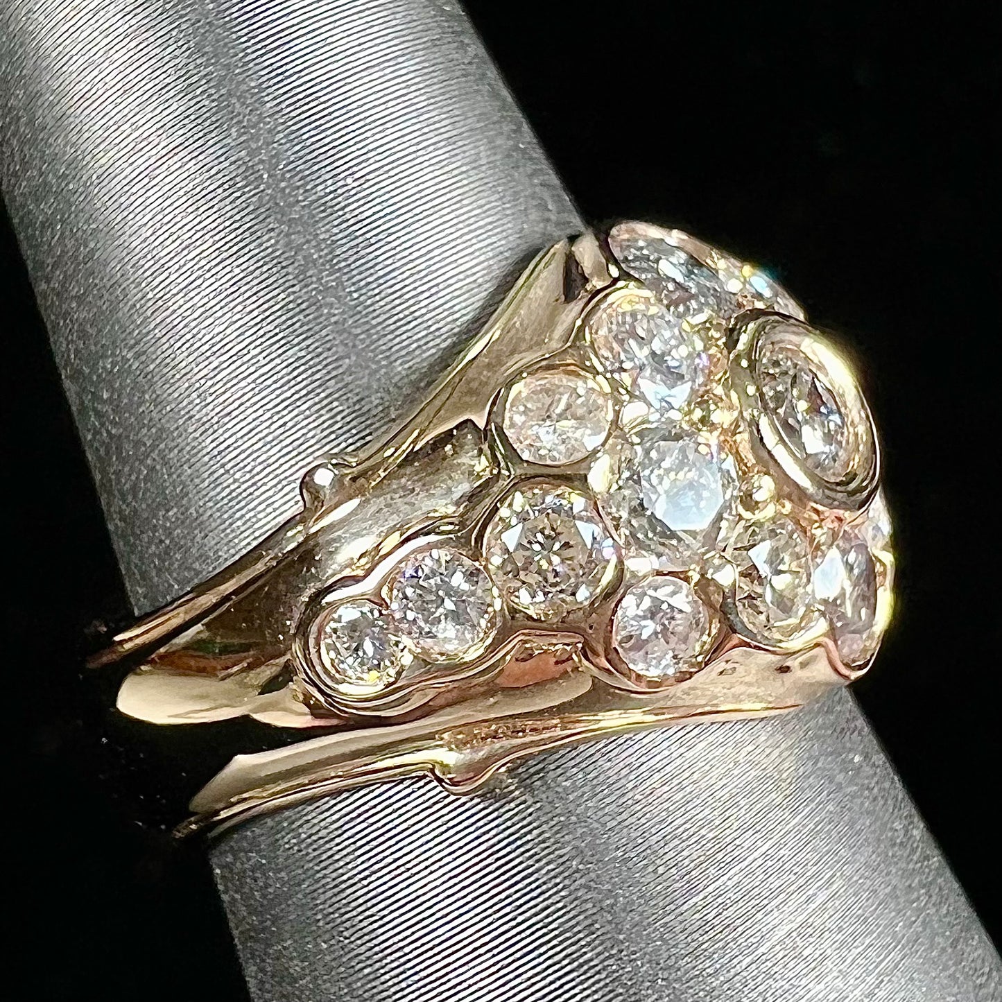A yellow gold domed diamond ring set with 19 Standard Round Brilliant Cut diamonds.