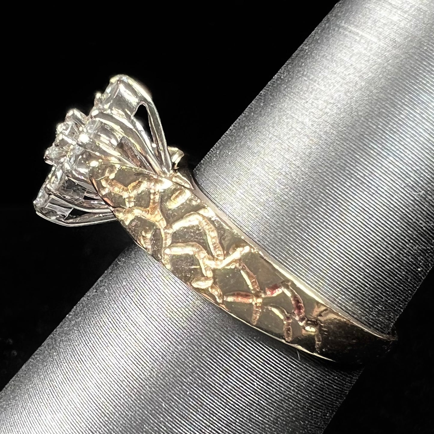 A ladies' estate diamond cluster ring cast in yellow gold. The shank has a nugget design.