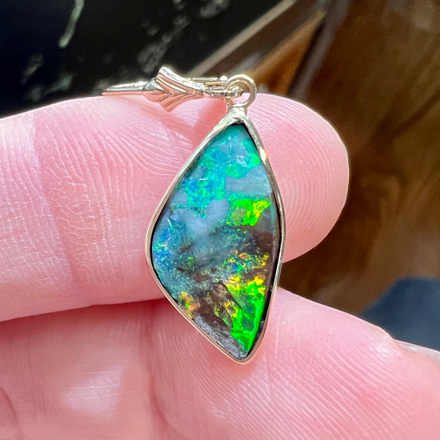 A pair of yellow gold dangle earrings set with Australian boulder opal stones.