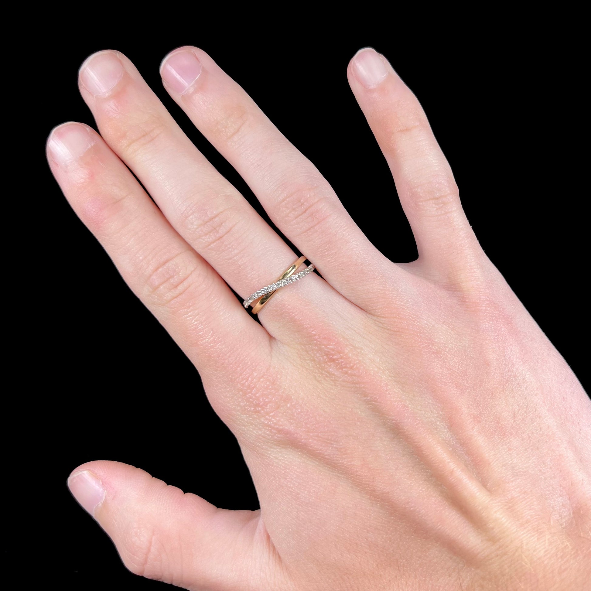 A ladies' two tone yellow and white gold twisted shank ring pave set with round single cut diamonds.