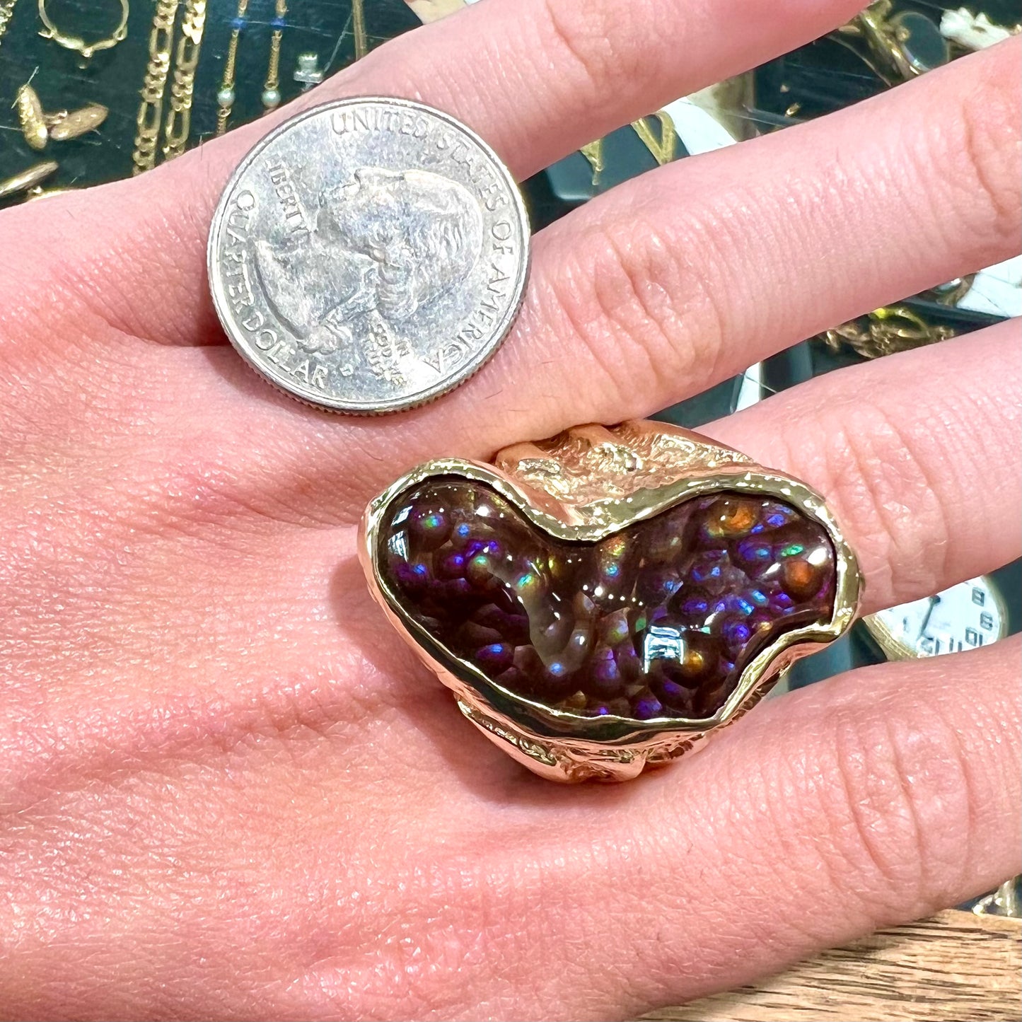 A men's Deer Creek fire agate solitaire ring cast in yellow gold. The stone is predominantly purple.