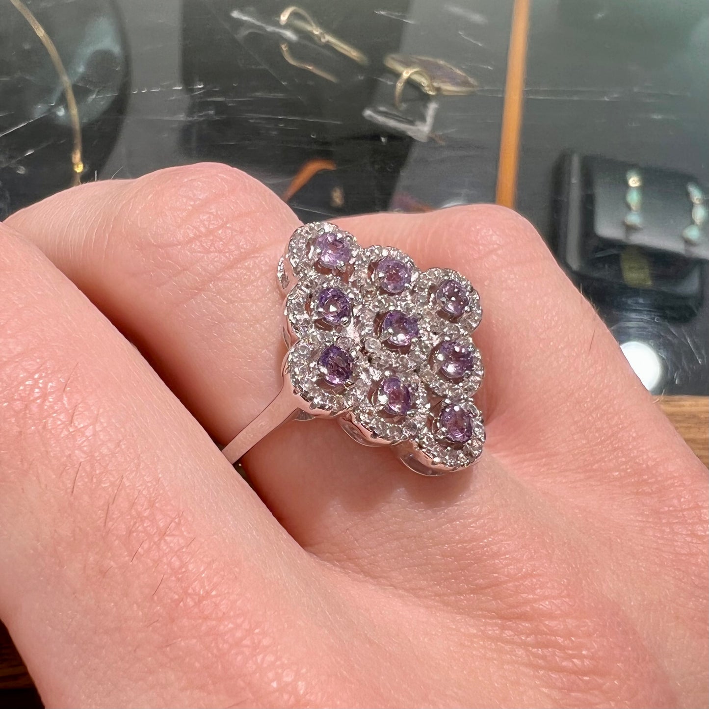 A silver ladies' ring set with 9 rose de France amethyst stones in white topaz halos.