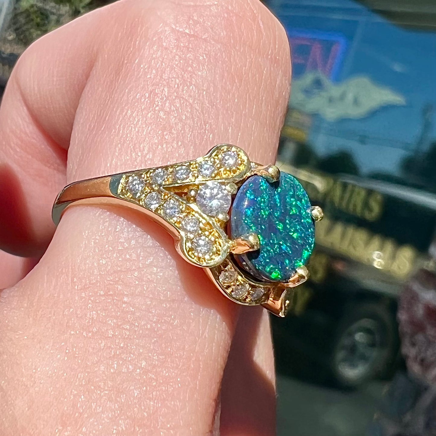 A ladies' 18kt yellow gold Lightning Ridge black opal and pave set diamond ring.