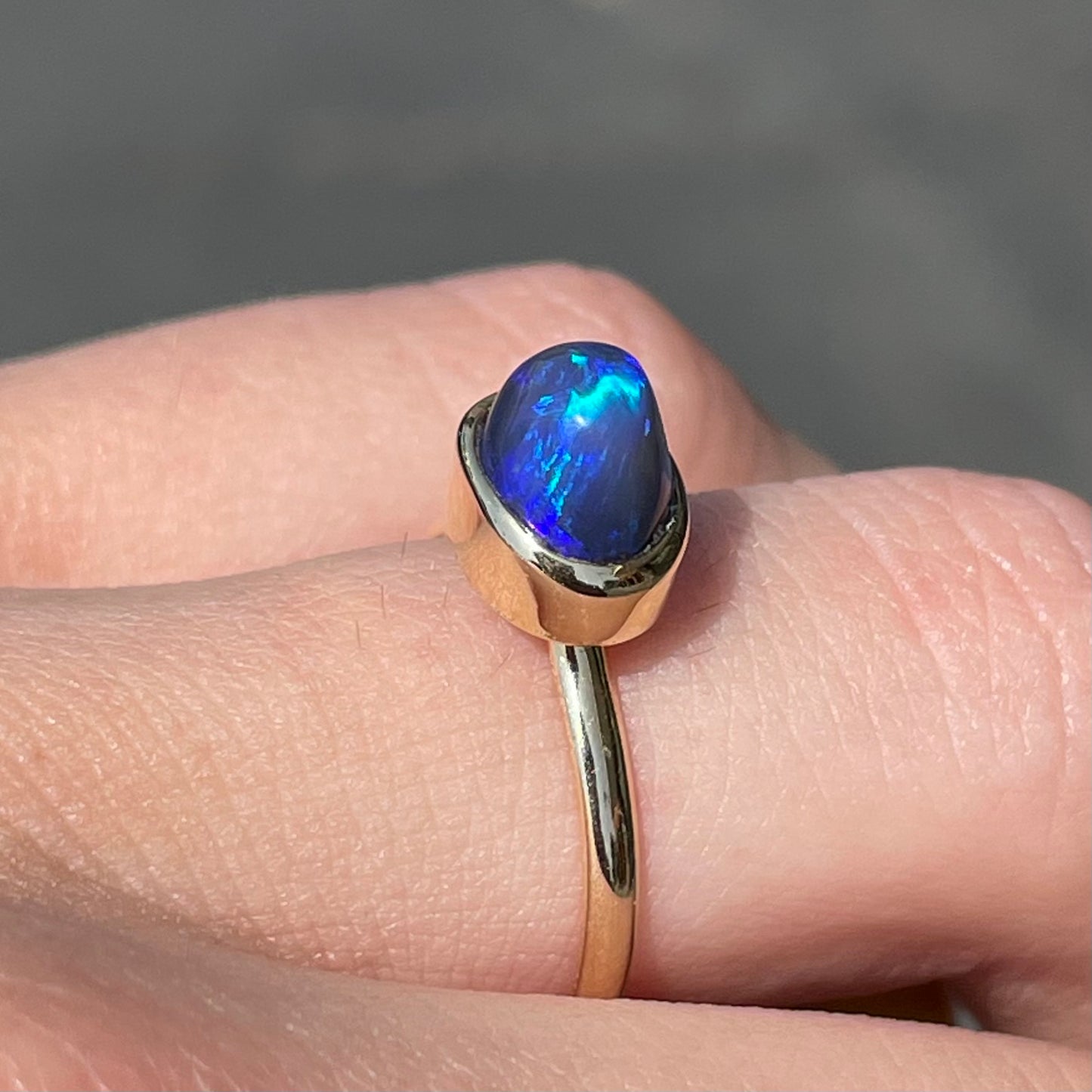 A ladies' black crystal opal solitaire ring set in yellow gold.