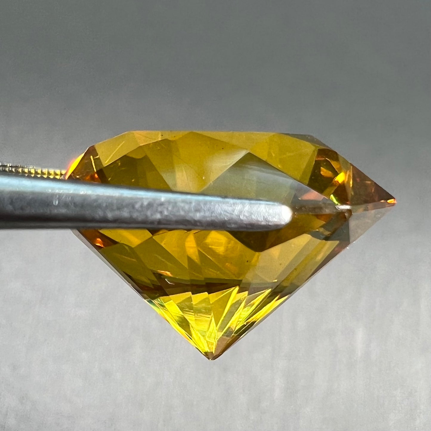 A loose, faceted octagonal cut golden amber stone. There are no bug inclusions visible.