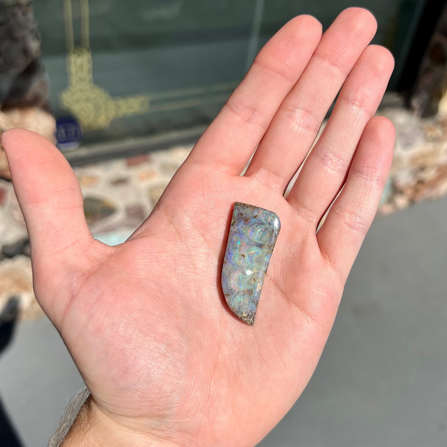A loose, freeform cut, natural boulder opal stone from Quilpie, Australia.