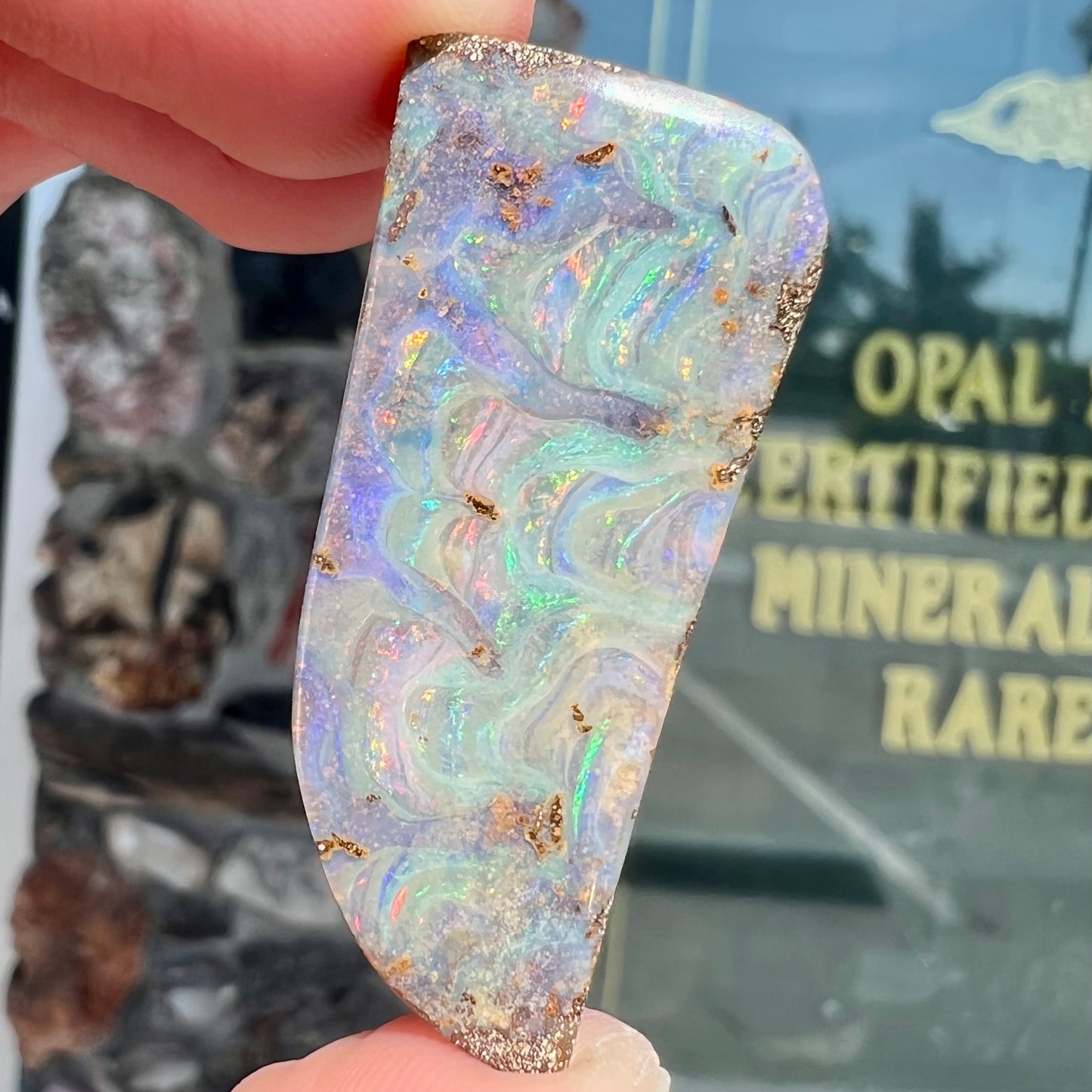 A loose, freeform cut, natural boulder opal stone from Quilpie, Australia.