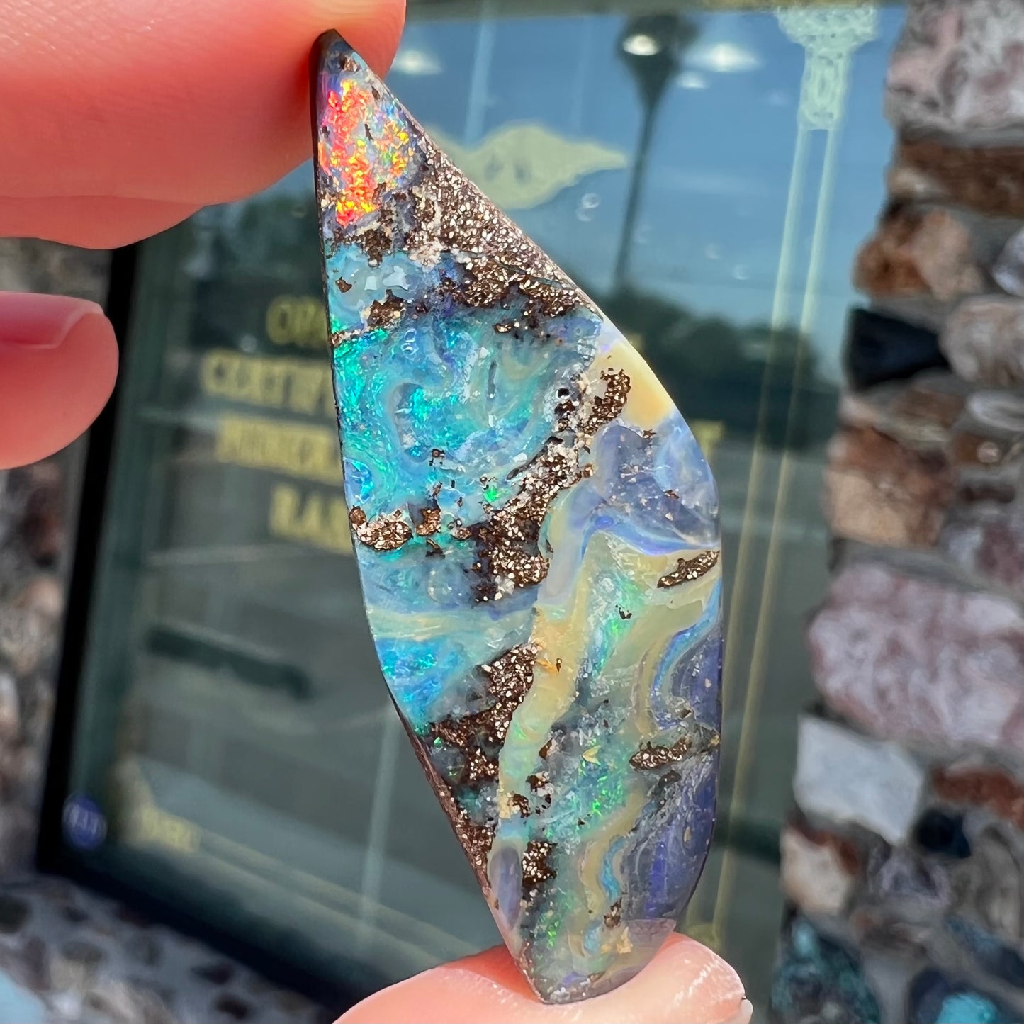 A loose Quilpie boulder opal stone. The stone is blue and has a bright rainbow tip.