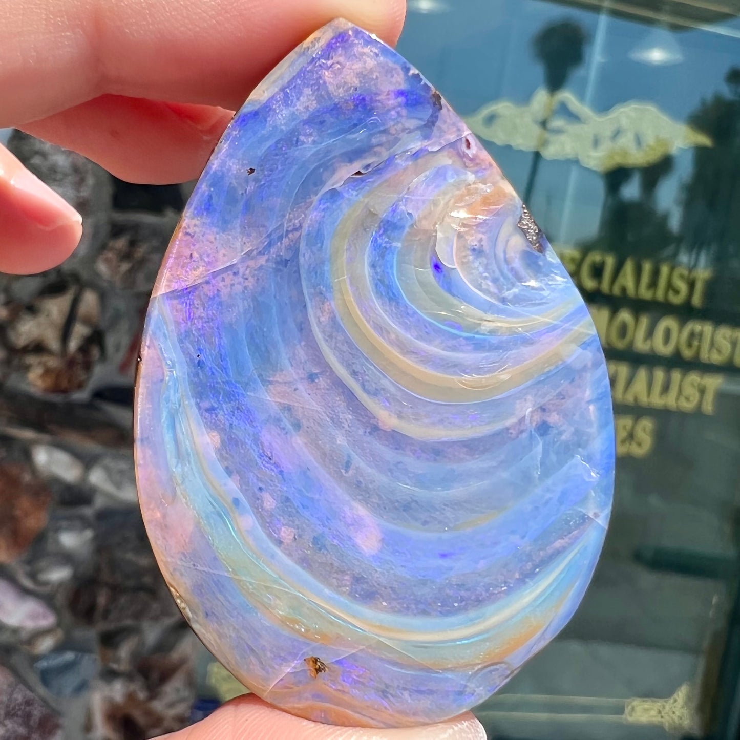 A loose, polished Quilpie boulder opal stone from Queensland, Australia. The opal displays a blue flow pattern.