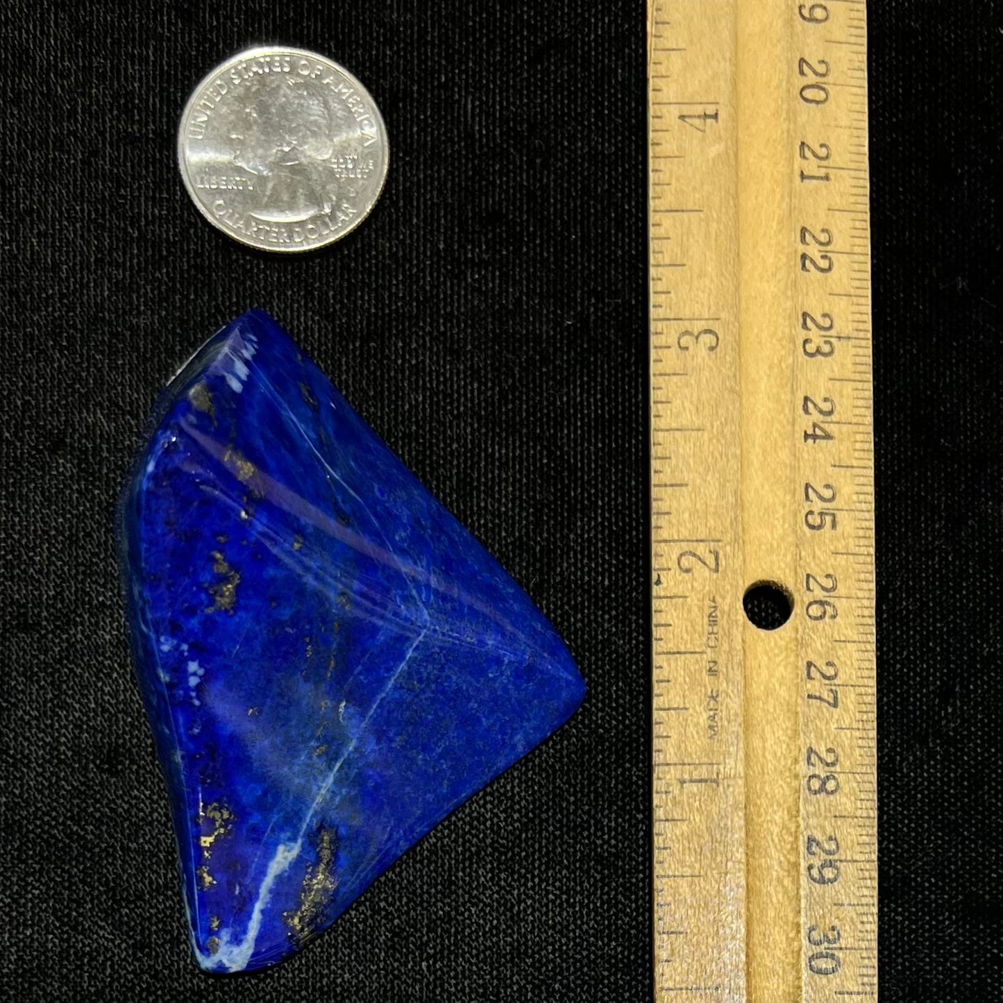 A loose polished sculpture made from royal blue lapis lazuli with golden pyrite inclusions.